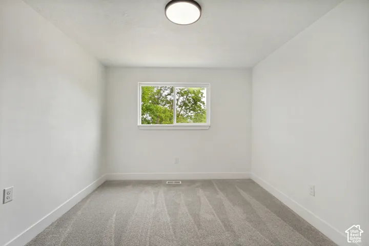 Neutral-toned 2nd bedroom featuring a single window, recessed lighting, and gray carpeting