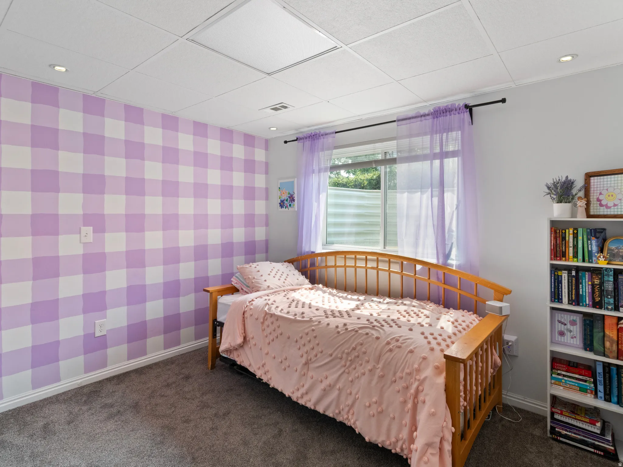 Room featuring a patterned accent wall, recessed lighting, and a drop ceiling