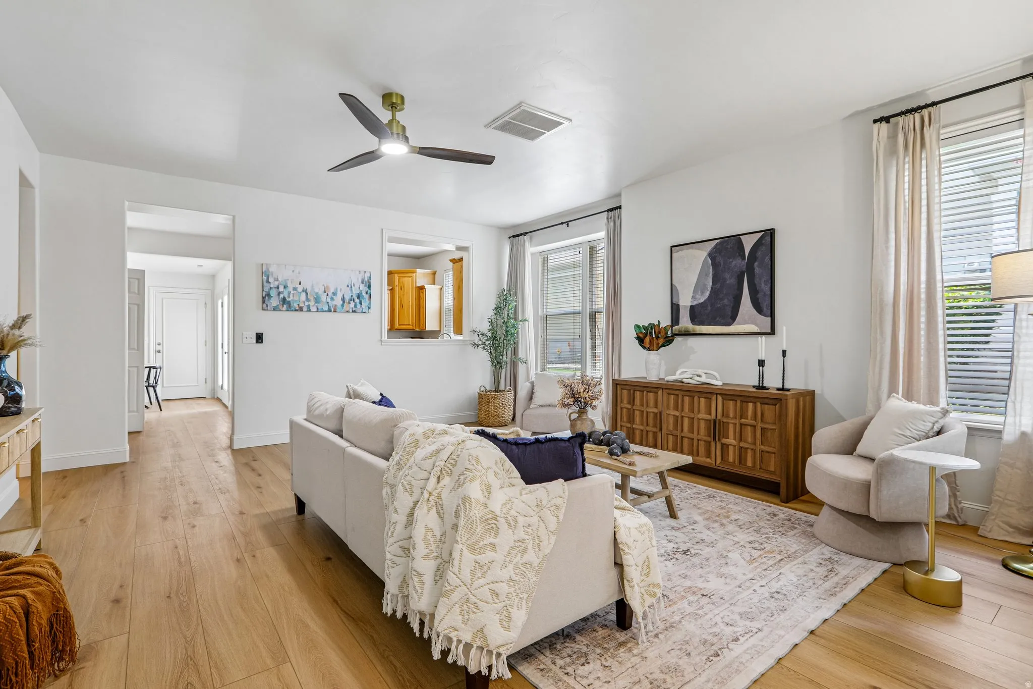 Spacious living area featuring wood-finish flooring, recessed lighting, and a modern ceiling fan