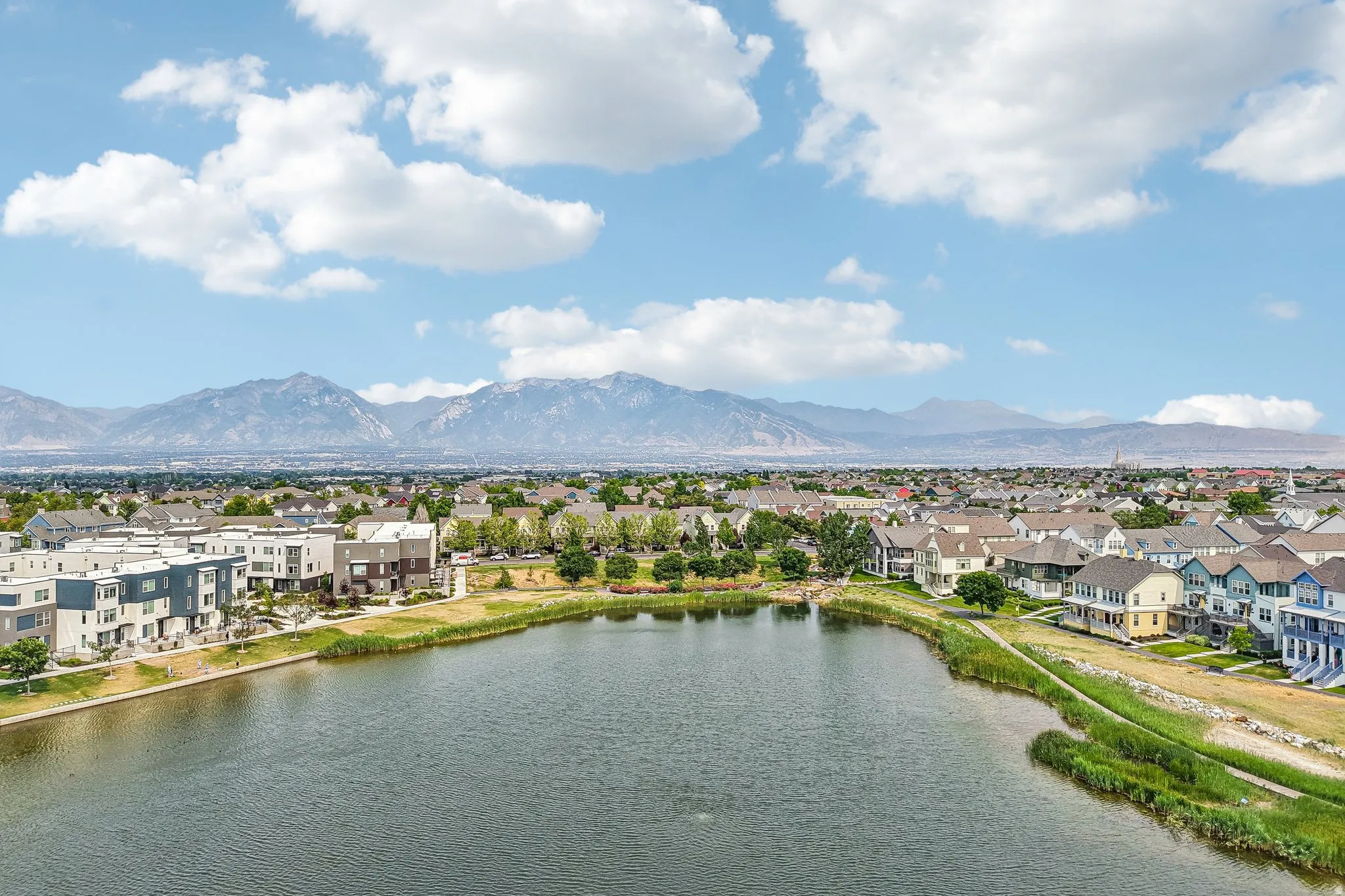 Expansive community lake bordered by residential properties and green spaces