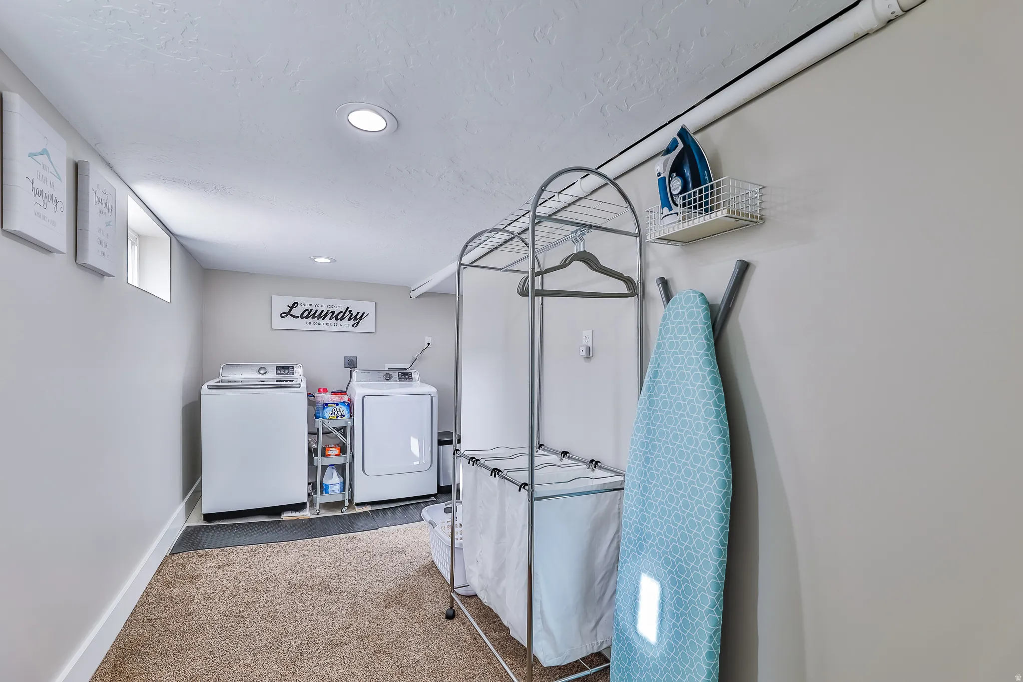 Dedicated laundry space featuring a window, recessed lighting, and a neutral color palette