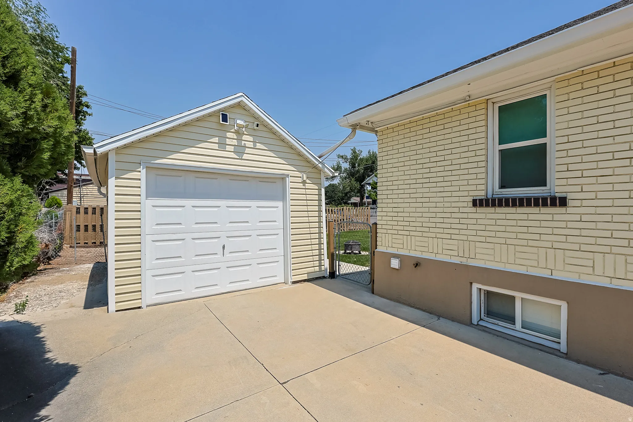 Detached garage featuring light-colored horizontal siding and a white panel garage door