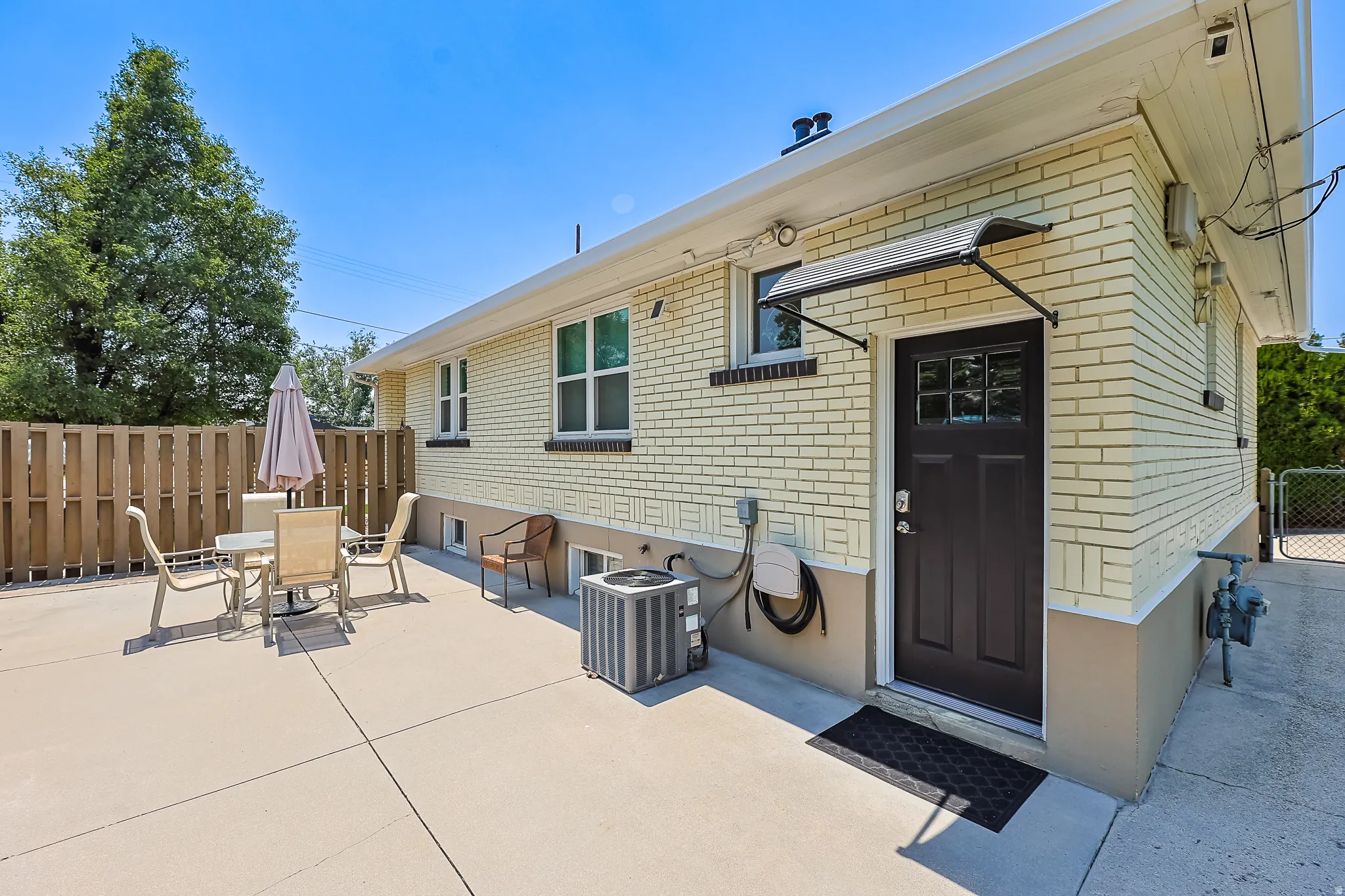 Expansive concrete patio bordered by a wood privacy fence