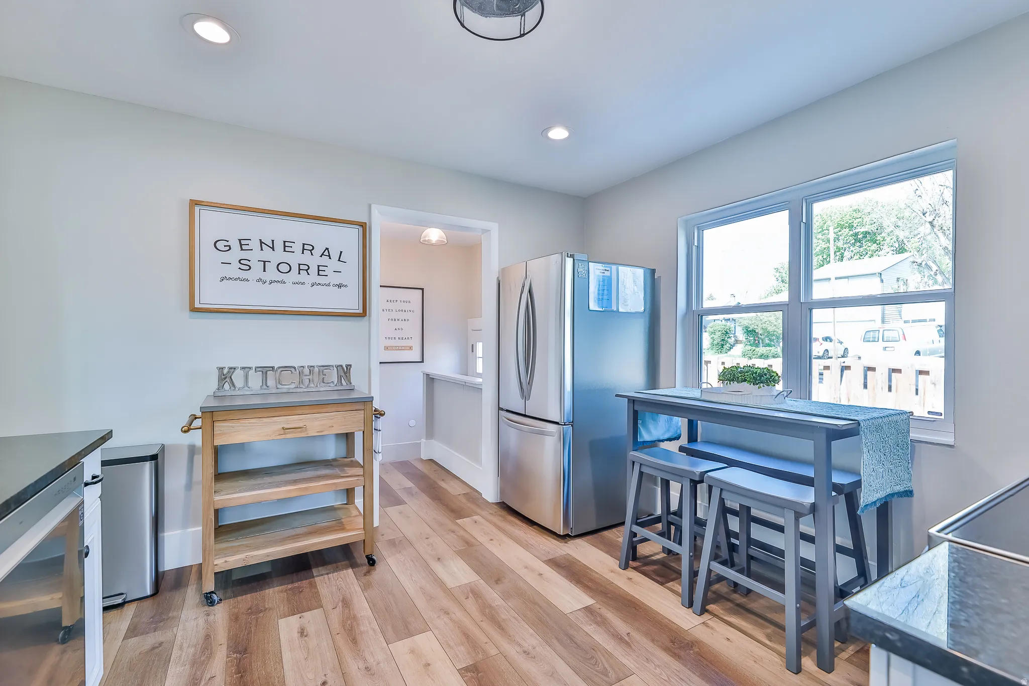 Kitchen area featuring wood-finish flooring, recessed lighting, and a stainless steel refrigerator