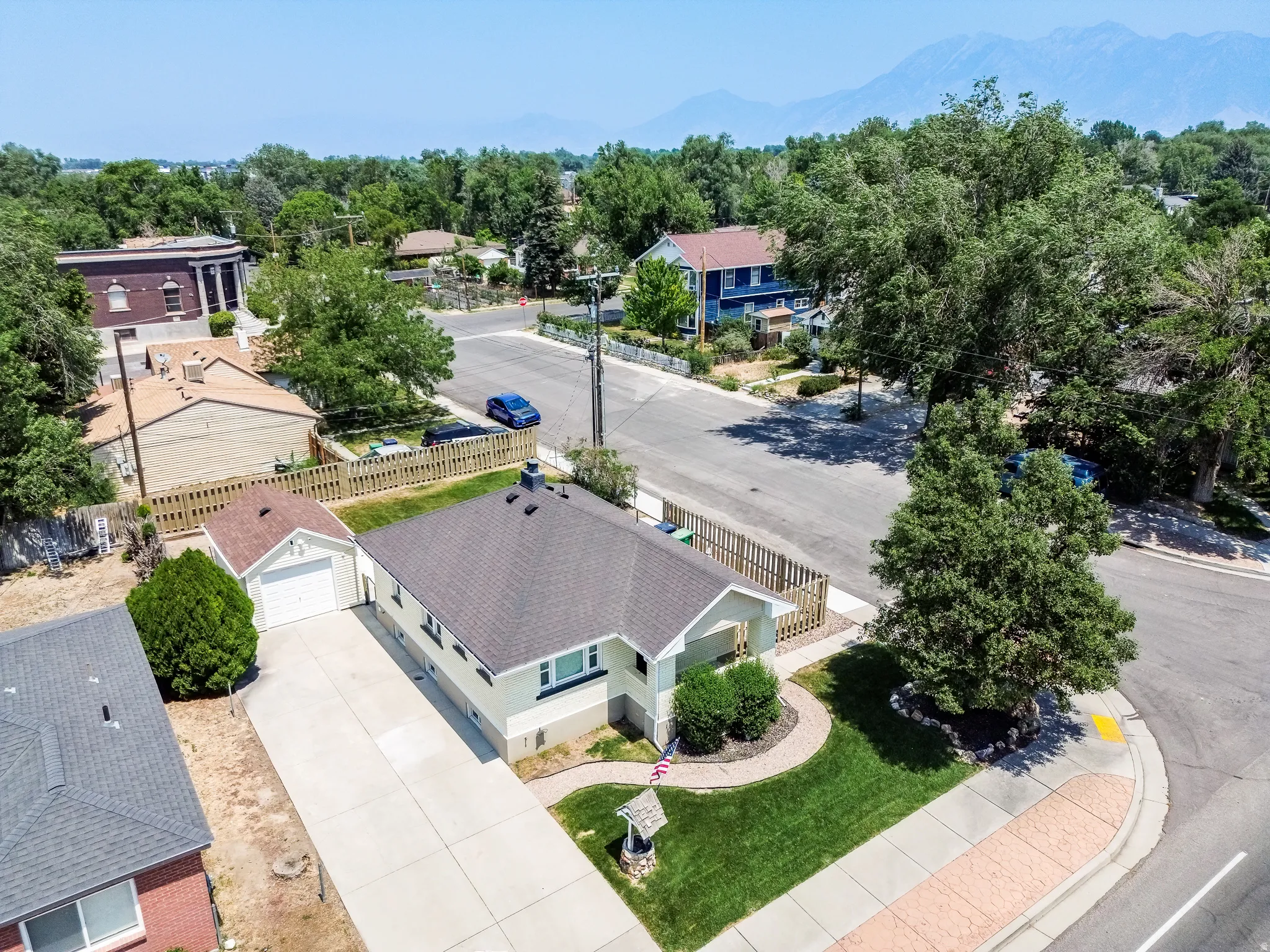 Single-story residence featuring a paved driveway, attached garage, and a lush green lawn