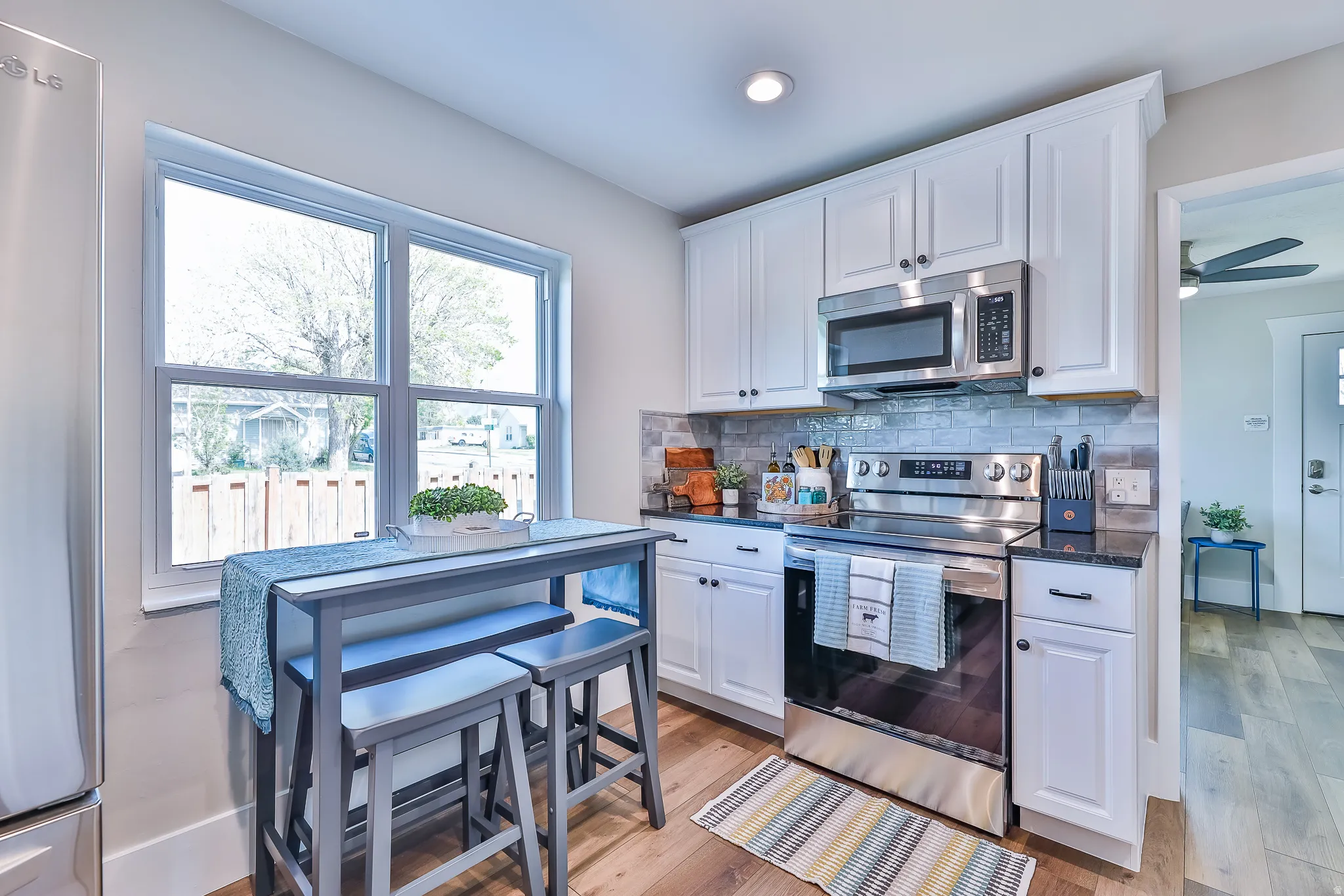 Modern kitchen featuring white cabinetry, dark countertops, and stainless steel appliances