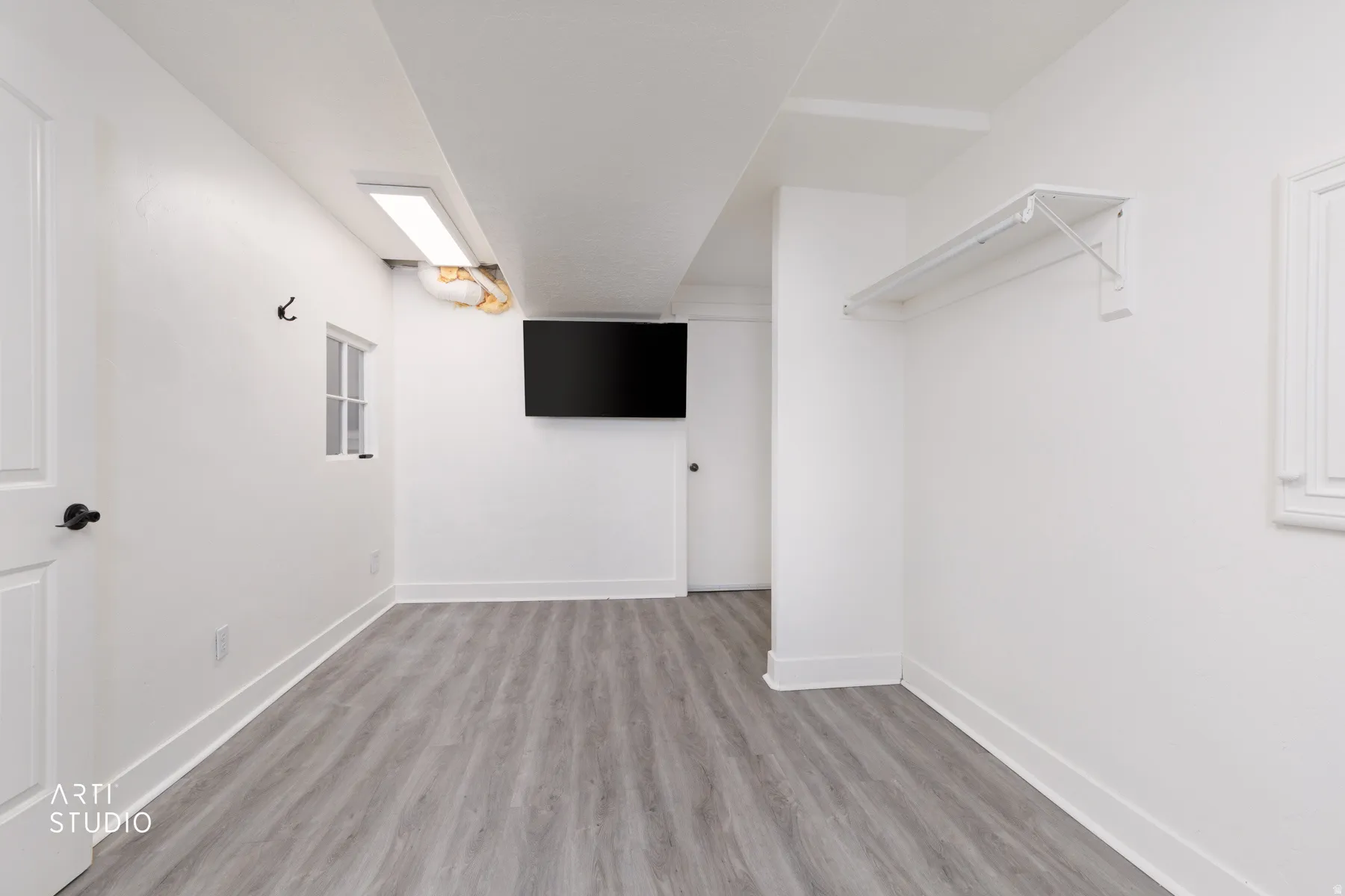 Spacious laundry/craft room featuring wood-finish flooring and crisp white walls