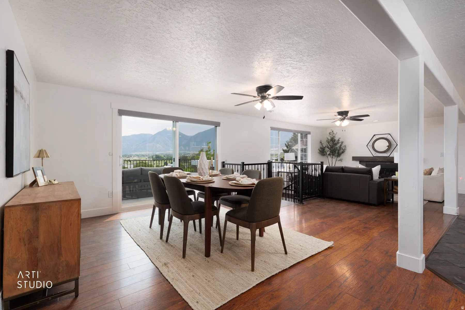 Open-concept dining area with wood-finish flooring, featuring a large sliding glass door opening to a private deck
