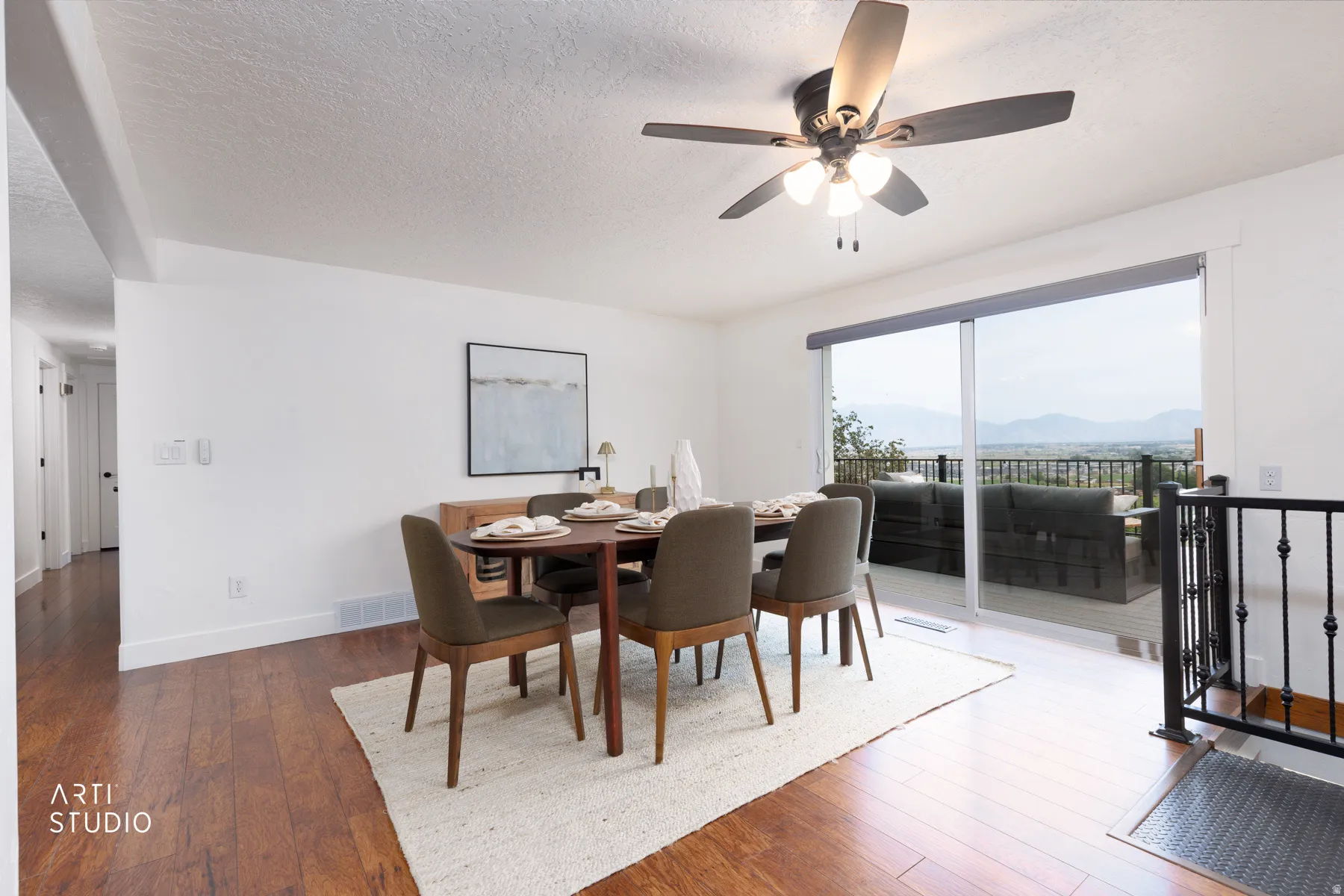 Bright interior featuring wood-finish flooring, white walls, and a contemporary ceiling fan