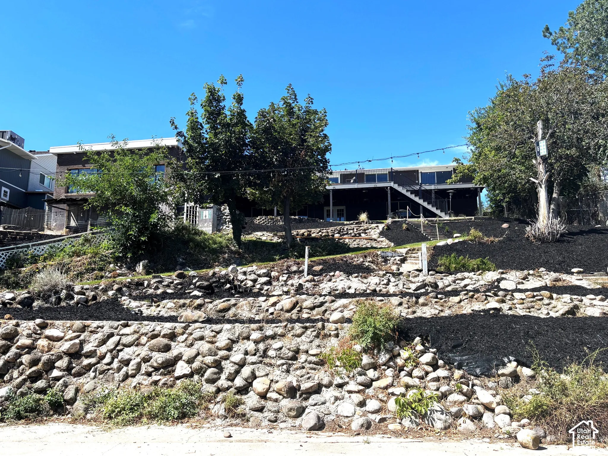 Exterior featuring a tiered landscape, stone retaining walls.