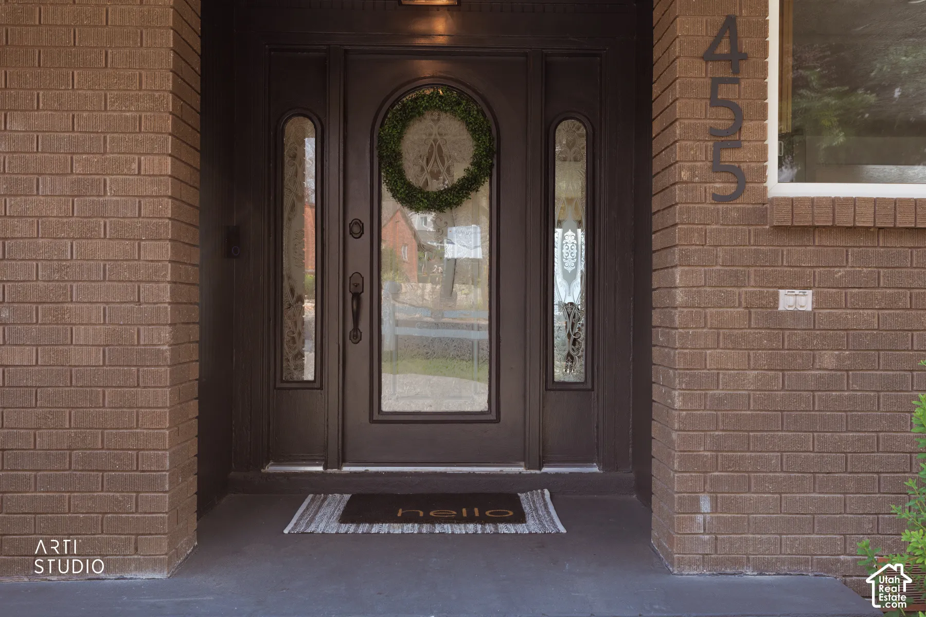 Brick exterior featuring a dark entry door with decorative glass inserts and sidelights