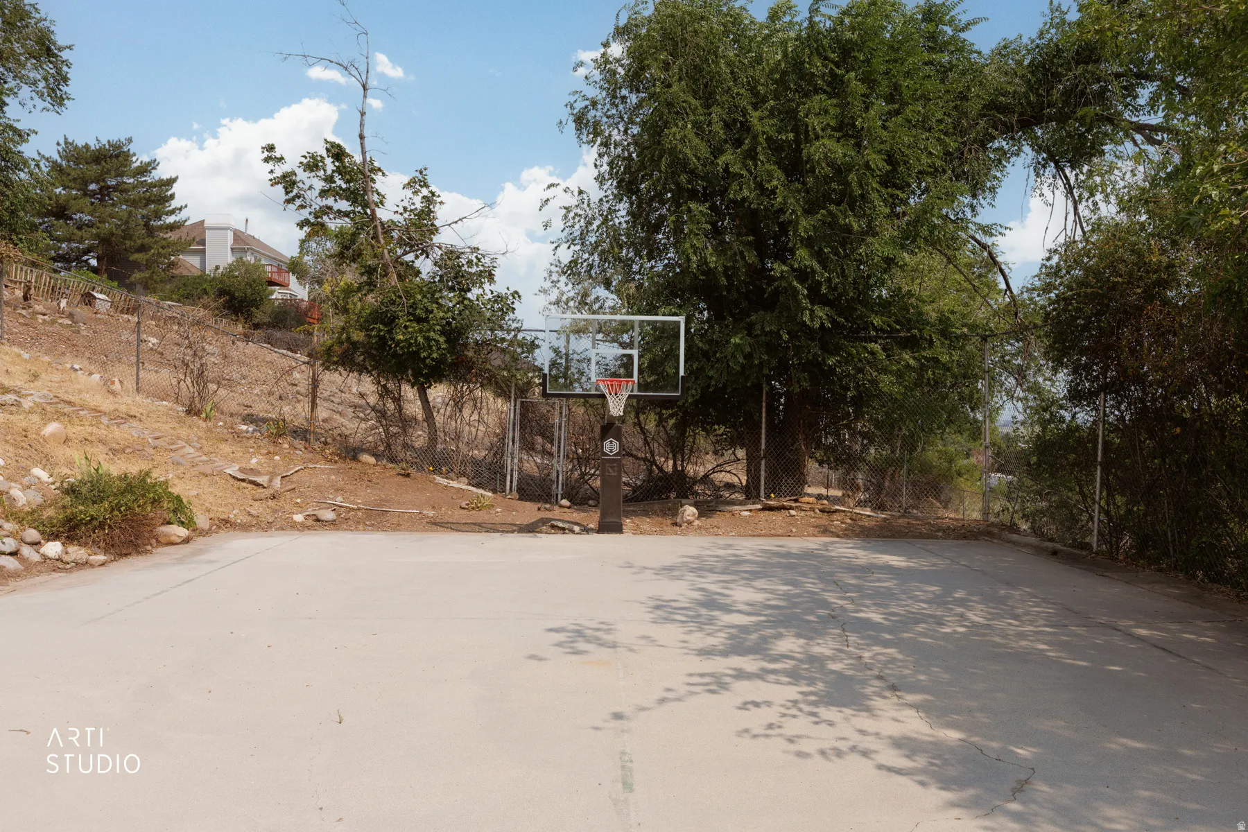 Paved full court featuring a basketball hoops with a clear backboard and red rim