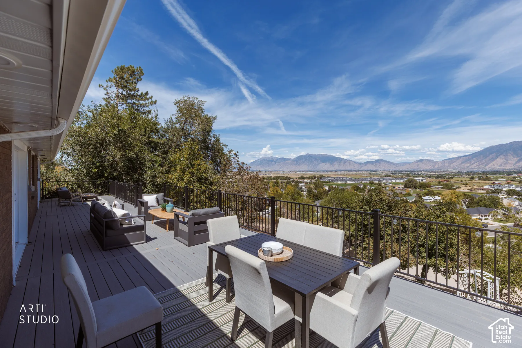 Expansive deck with composite decking, black metal railings, and a mountain range backdrop
