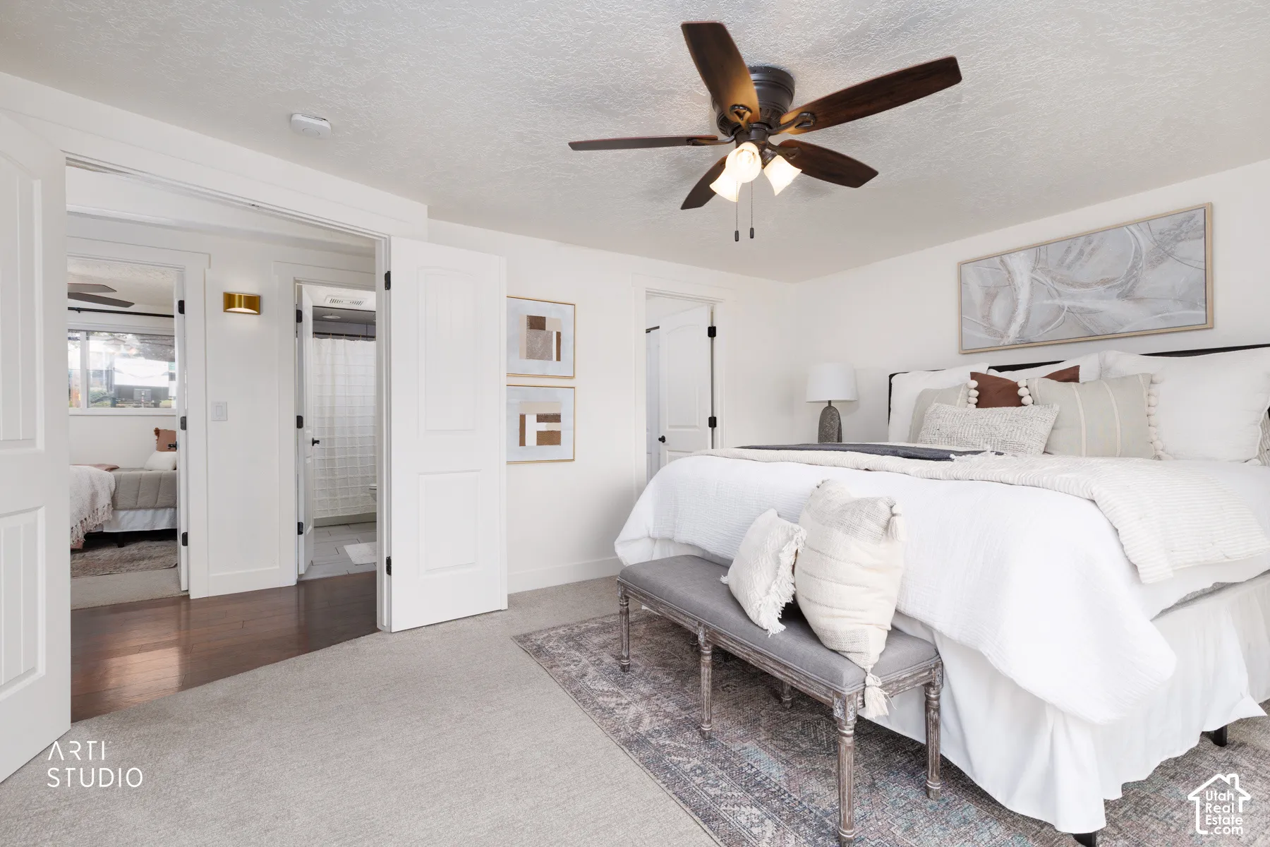 Carpeted room featuring a ceiling fan with integrated lighting, white walls, and white paneled doors