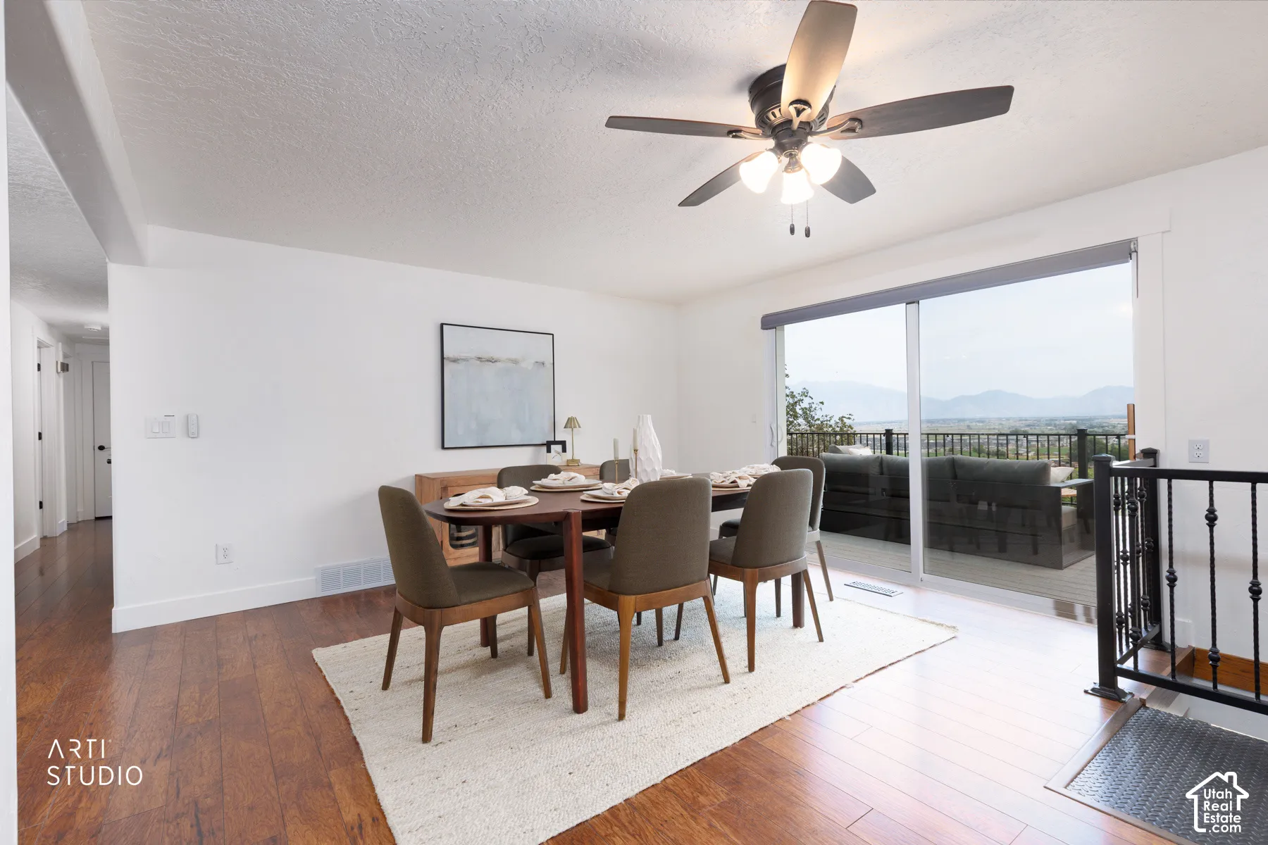 Bright interior featuring wood-finish flooring, white walls, and a contemporary ceiling fan