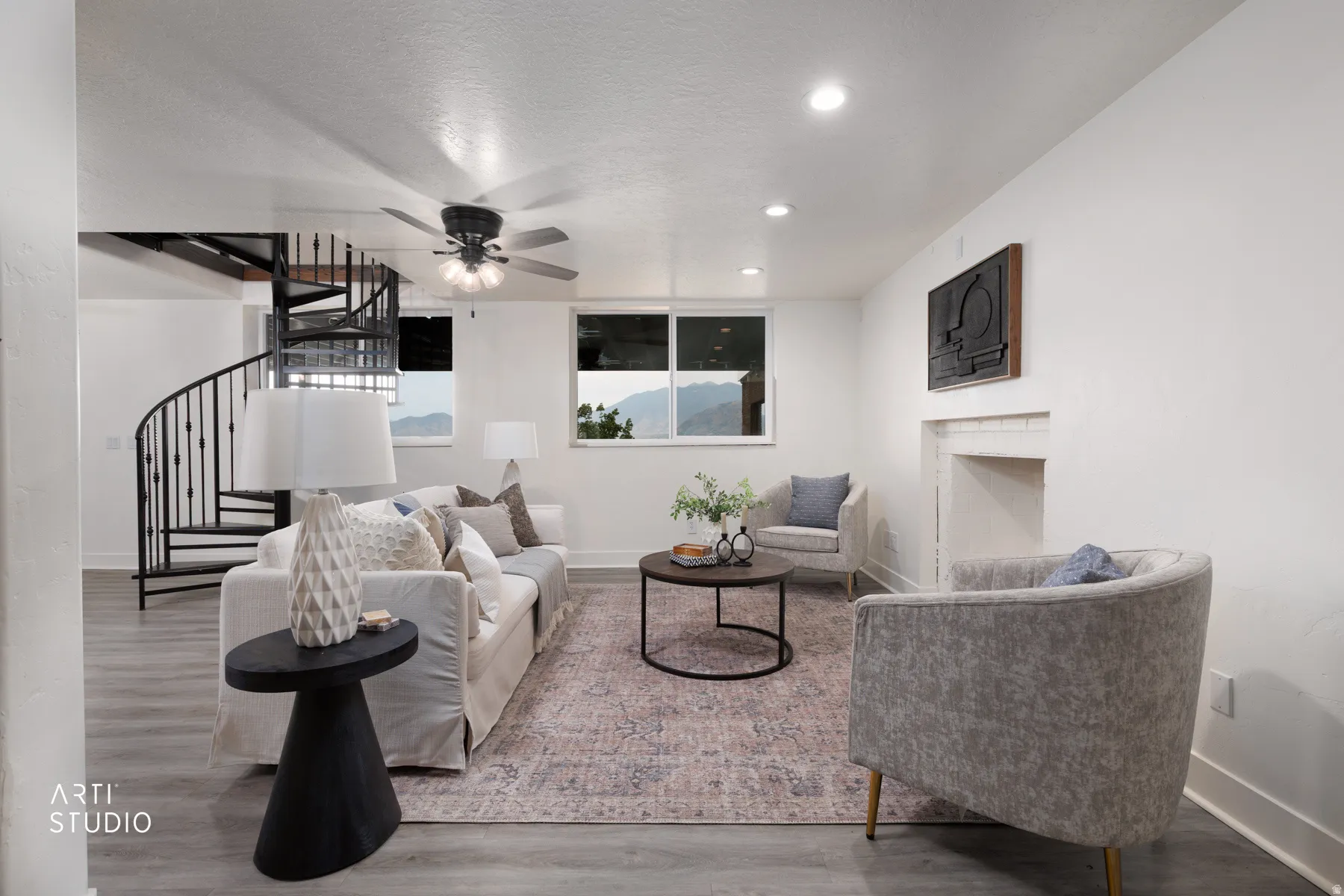Living space featuring wood-finish flooring, a spiral staircase with metal balusters, a ceiling fan with integrated lighting, recessed lighting, and a fireplace