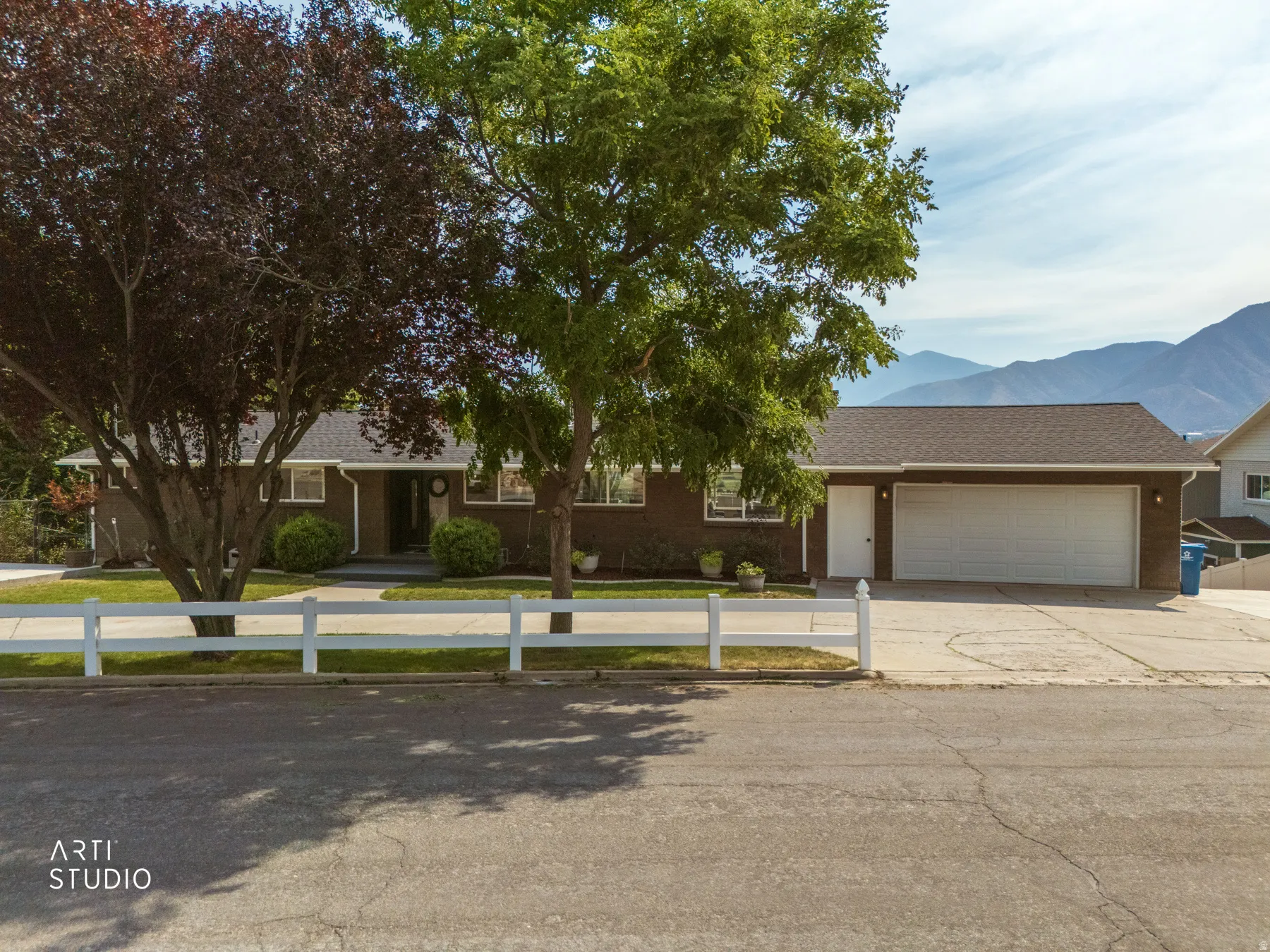 Ranch-style residence featuring a dark facade, white trim windows, and a brown shingle roof