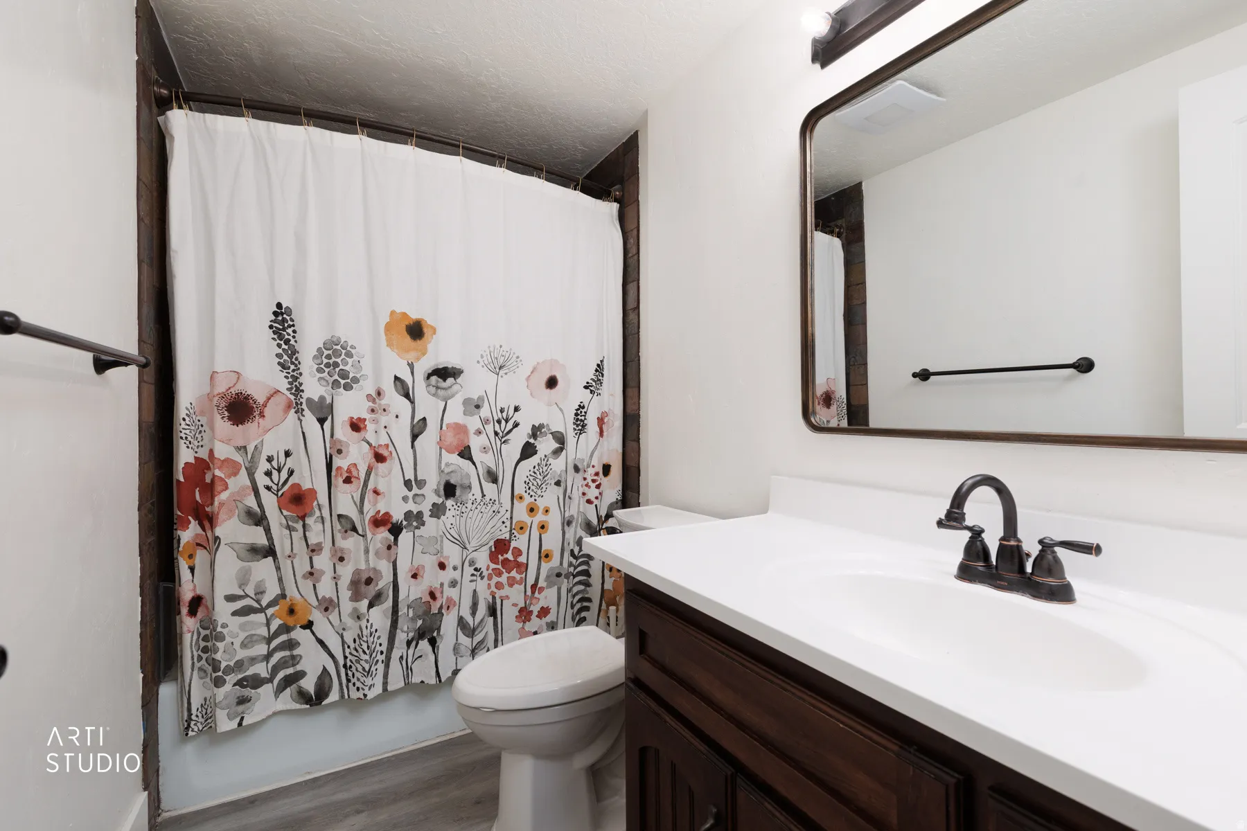 Bathroom featuring a dark wood vanity with white countertop, integrated sink, and an oil-rubbed bronze faucet