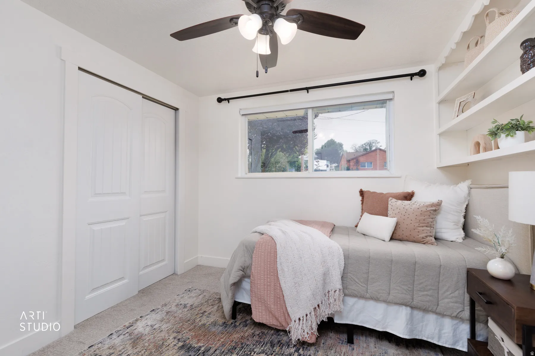 Room featuring a window, built-in shelving, a ceiling fan, and sliding closet doors
