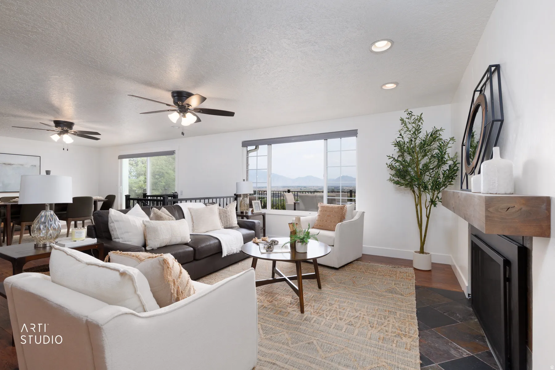 Spacious living area featuring large windows, wood-finish flooring, a fireplace with a wood mantle, and recessed lighting