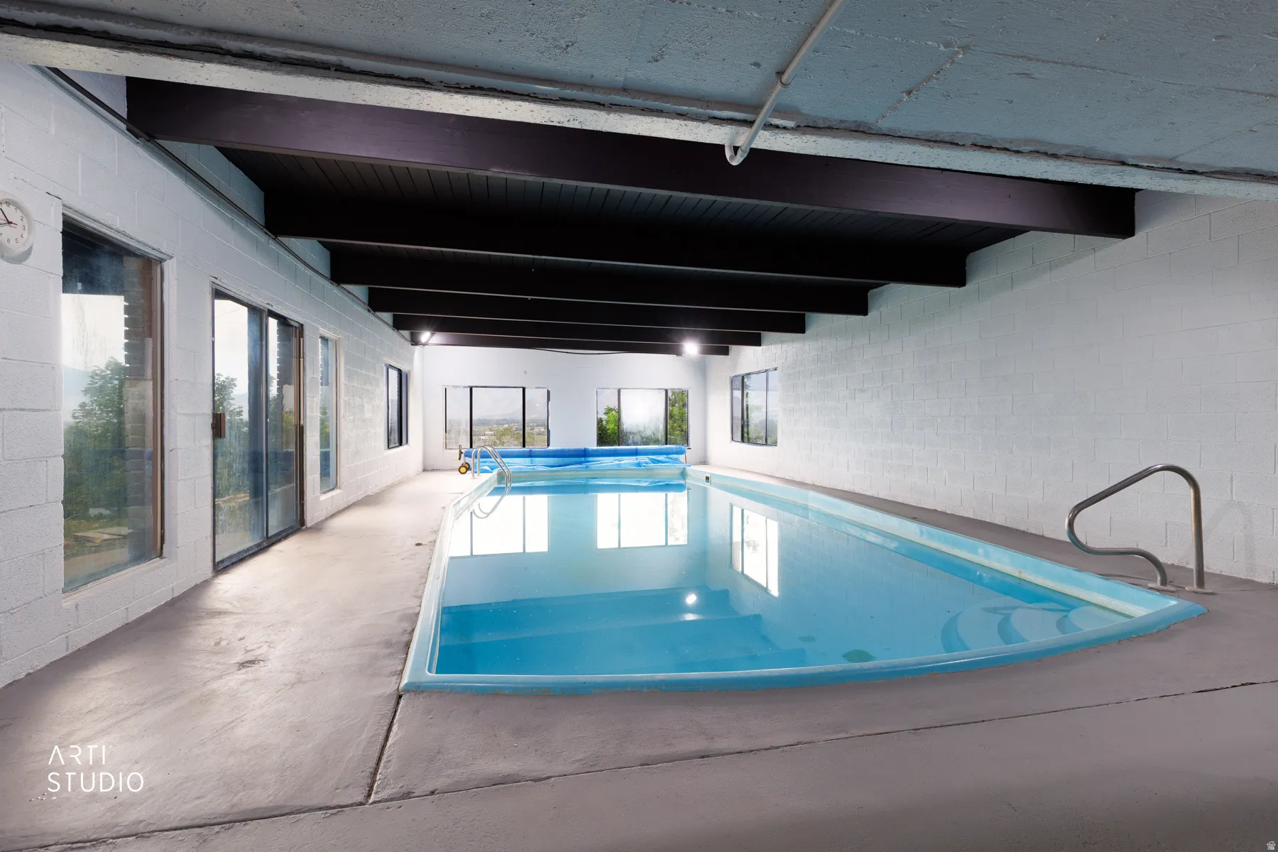 Indoor swimming pool featuring a curved end and integrated steps