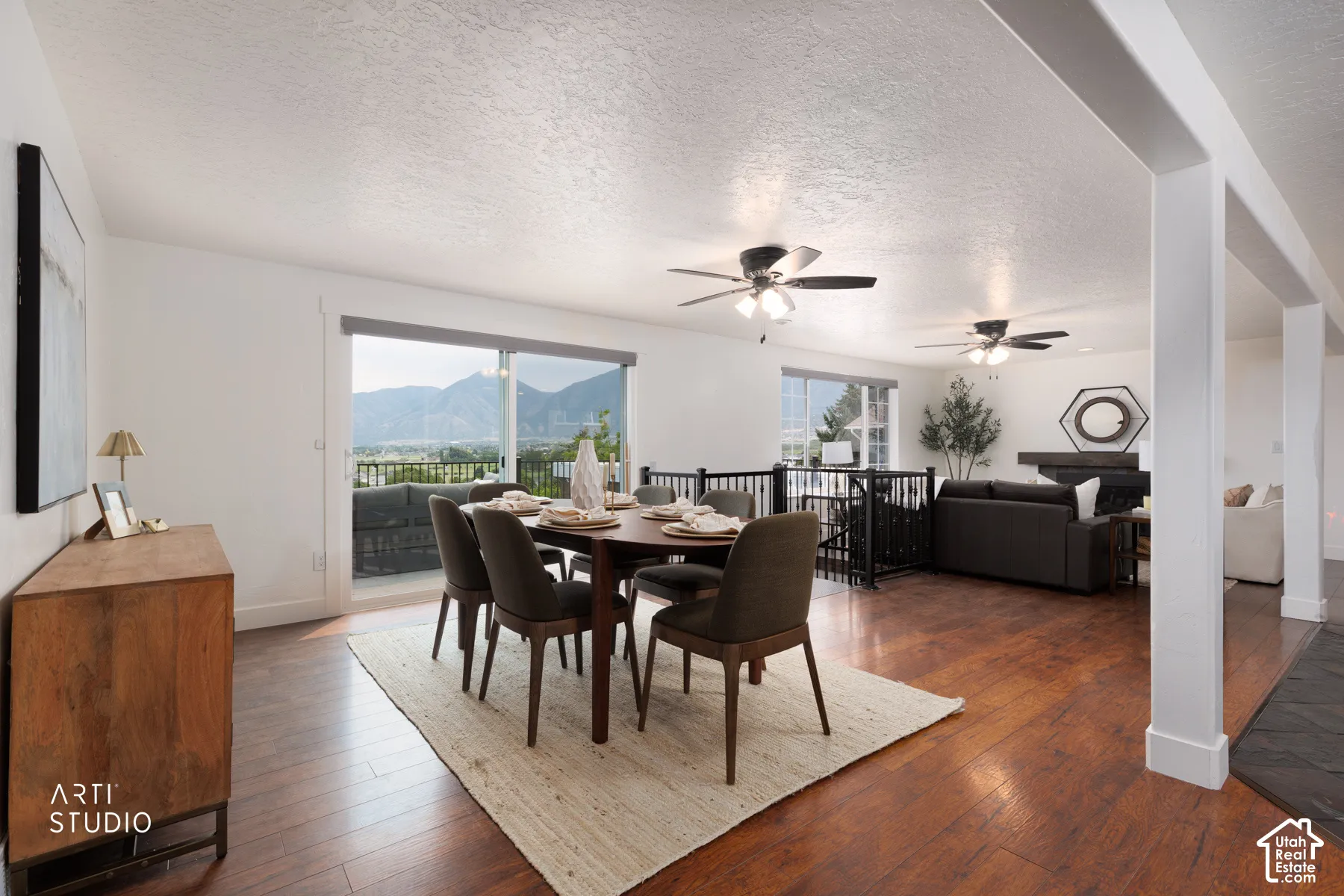 Open-concept dining area with wood-finish flooring, featuring a large sliding glass door opening to a private deck