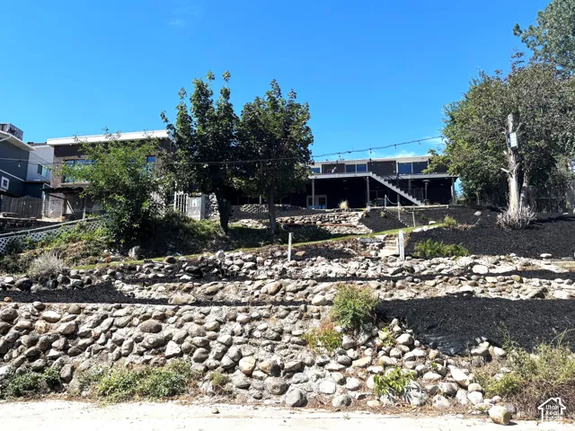 Exterior featuring a tiered landscape, stone retaining walls.
