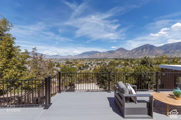 Expansive outdoor deck with composite decking and metal railings, showcasing distant mountain scenery and a community overview