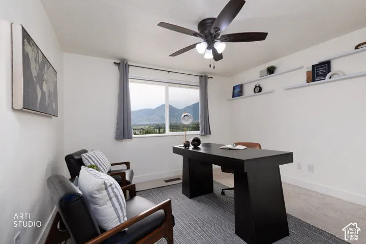 Room featuring a window with mountain scenery, a ceiling fan with integrated lighting, and white floating wall shelves
