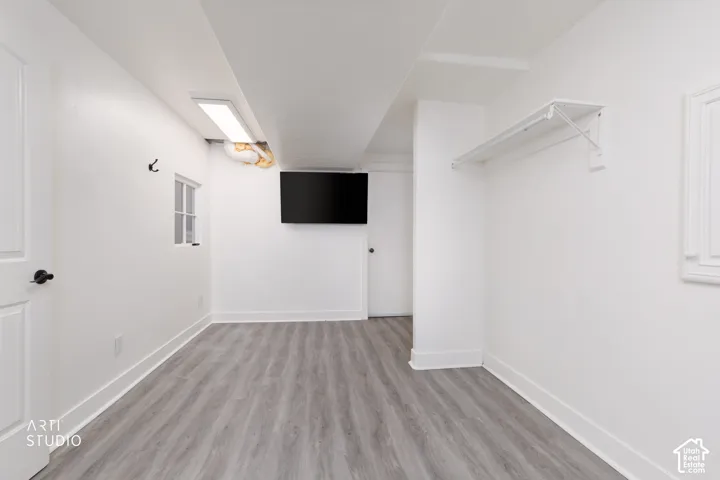 Spacious laundry/craft room featuring wood-finish flooring and crisp white walls