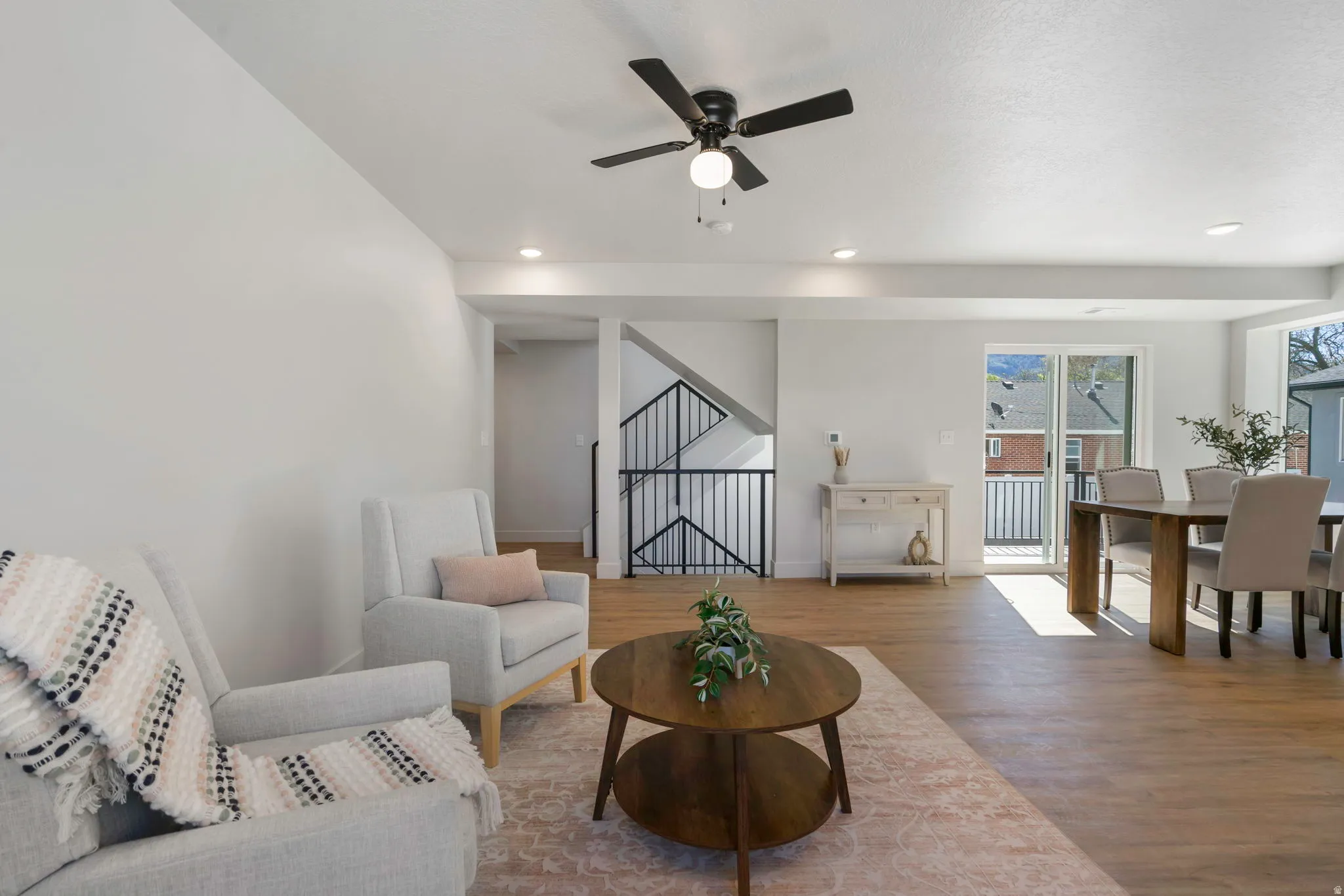 Open-concept living space featuring wood-finish flooring, recessed lighting, and a ceiling fan