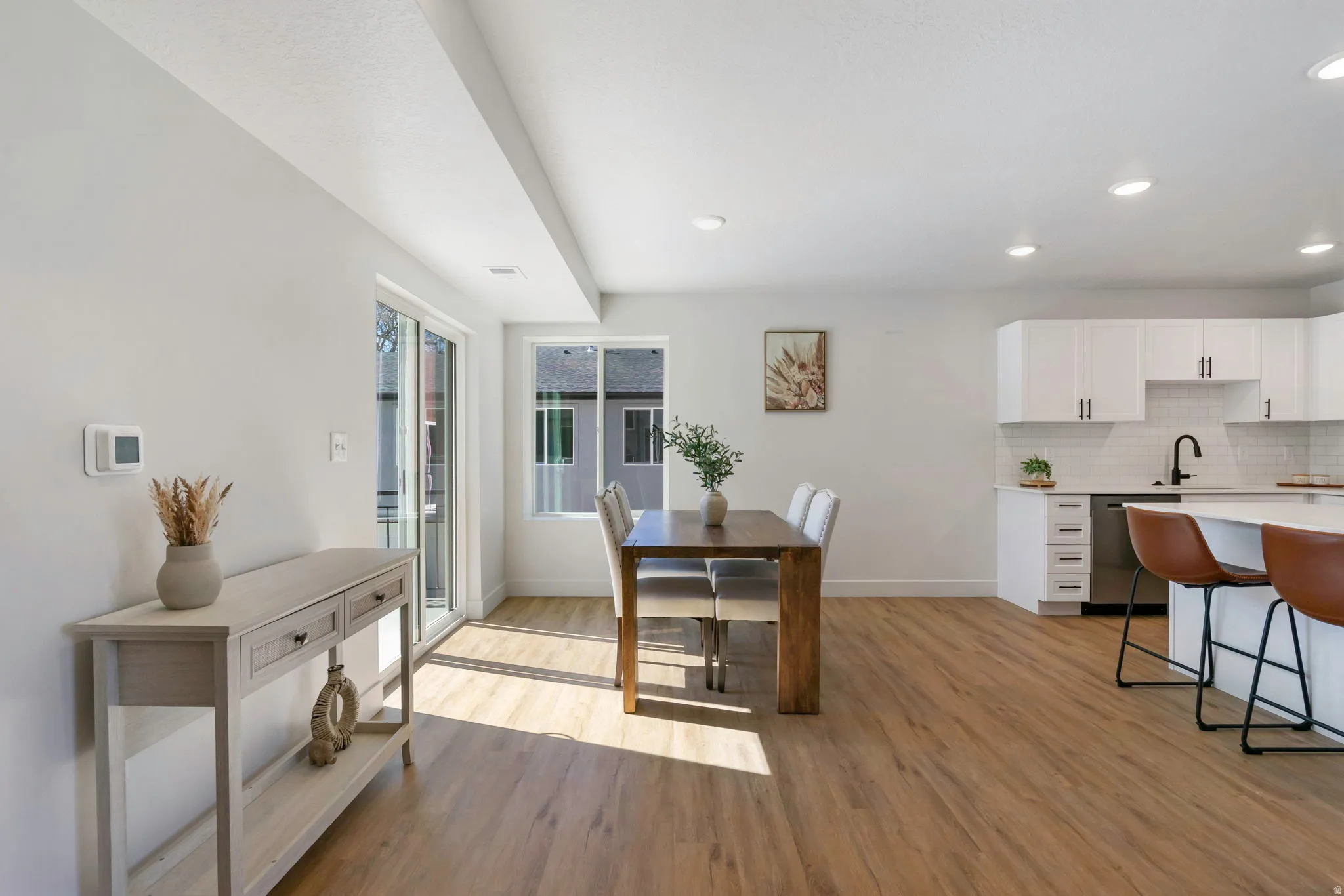 Open-concept living space featuring wood-finish flooring, white walls, and recessed lighting