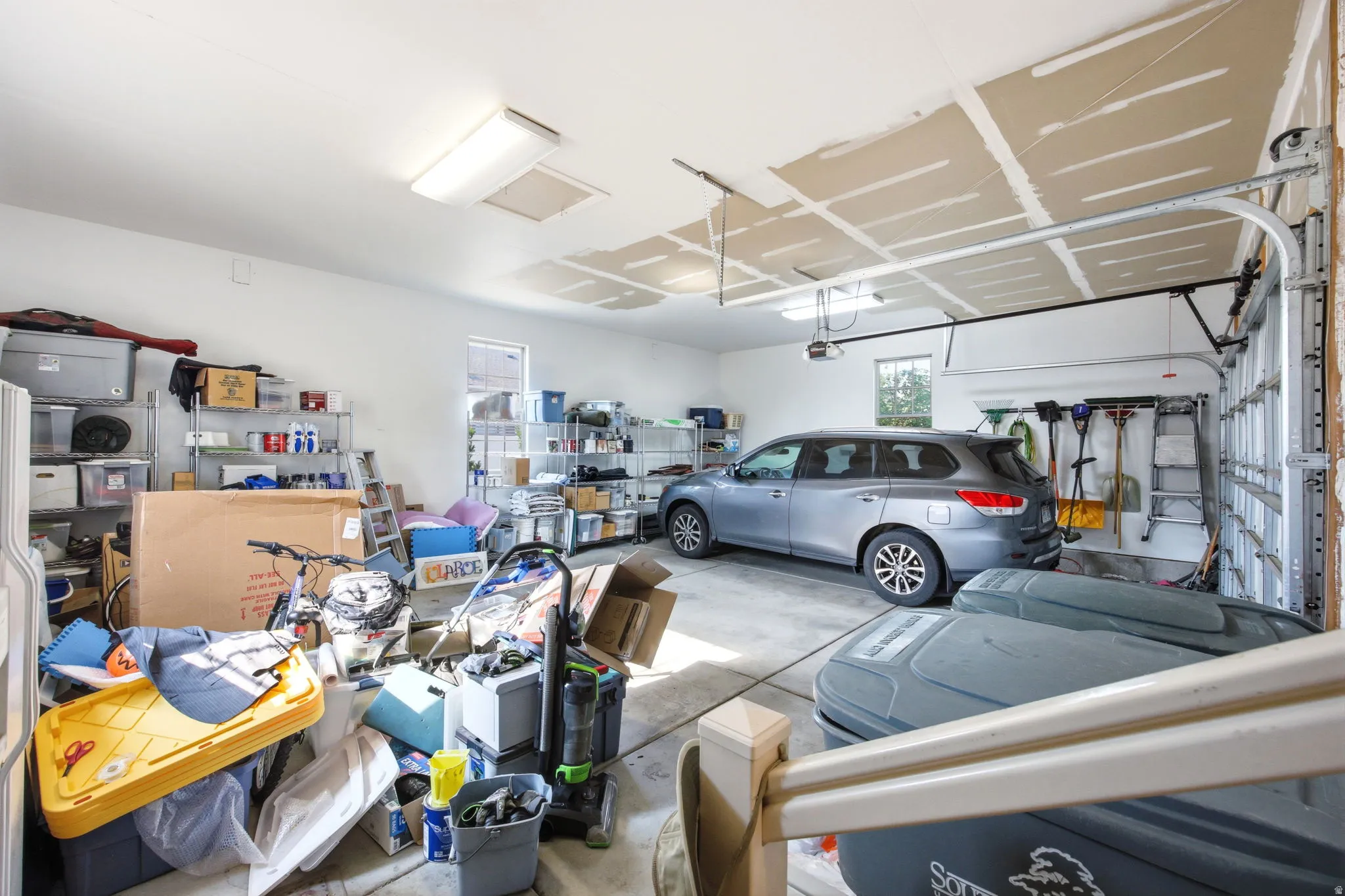 Spacious two-car garage with concrete flooring, automatic garage door opener, and natural light from a side window