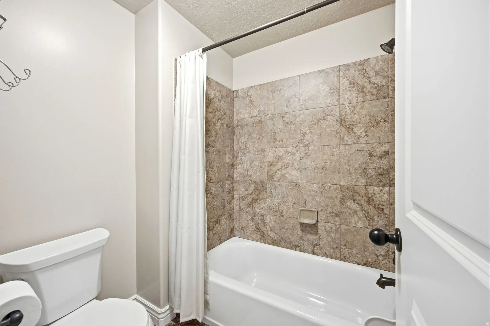 Tub and shower combination featuring large format tile surround
