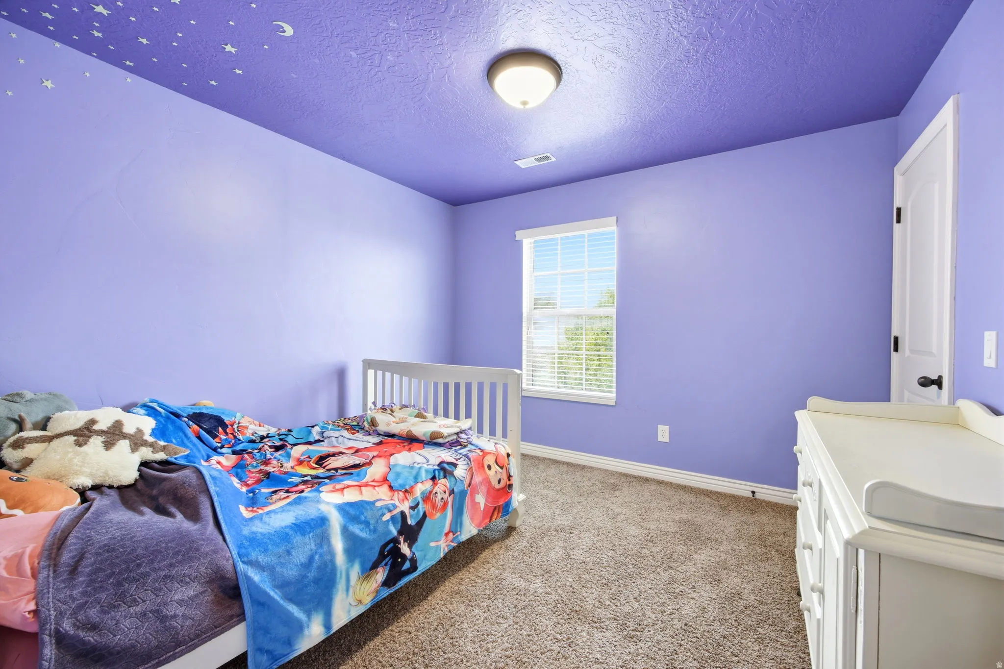 Room featuring purple walls with a textured ceiling