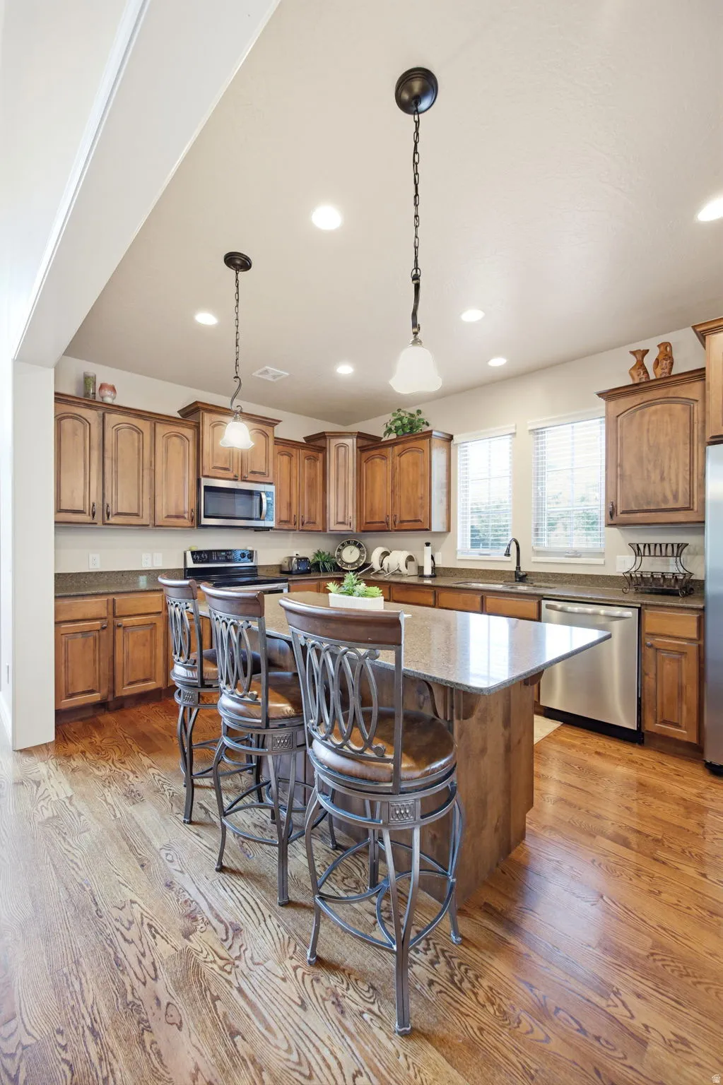 Kitchen featuring wood-finish flooring, recessed lighting, and a kitchen island with seating