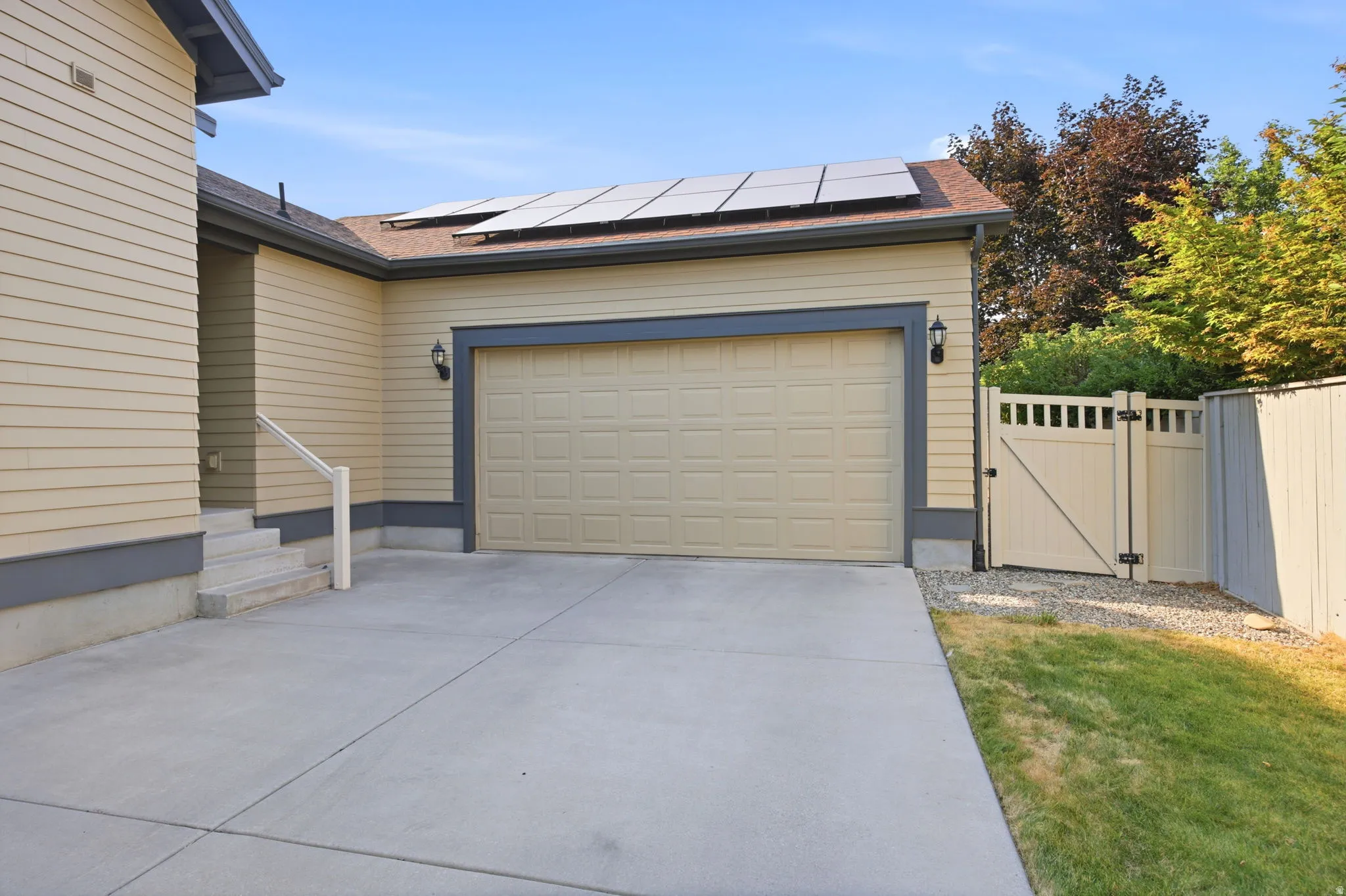 Attached two-car garage with overhead door, flanked by exterior wall sconces