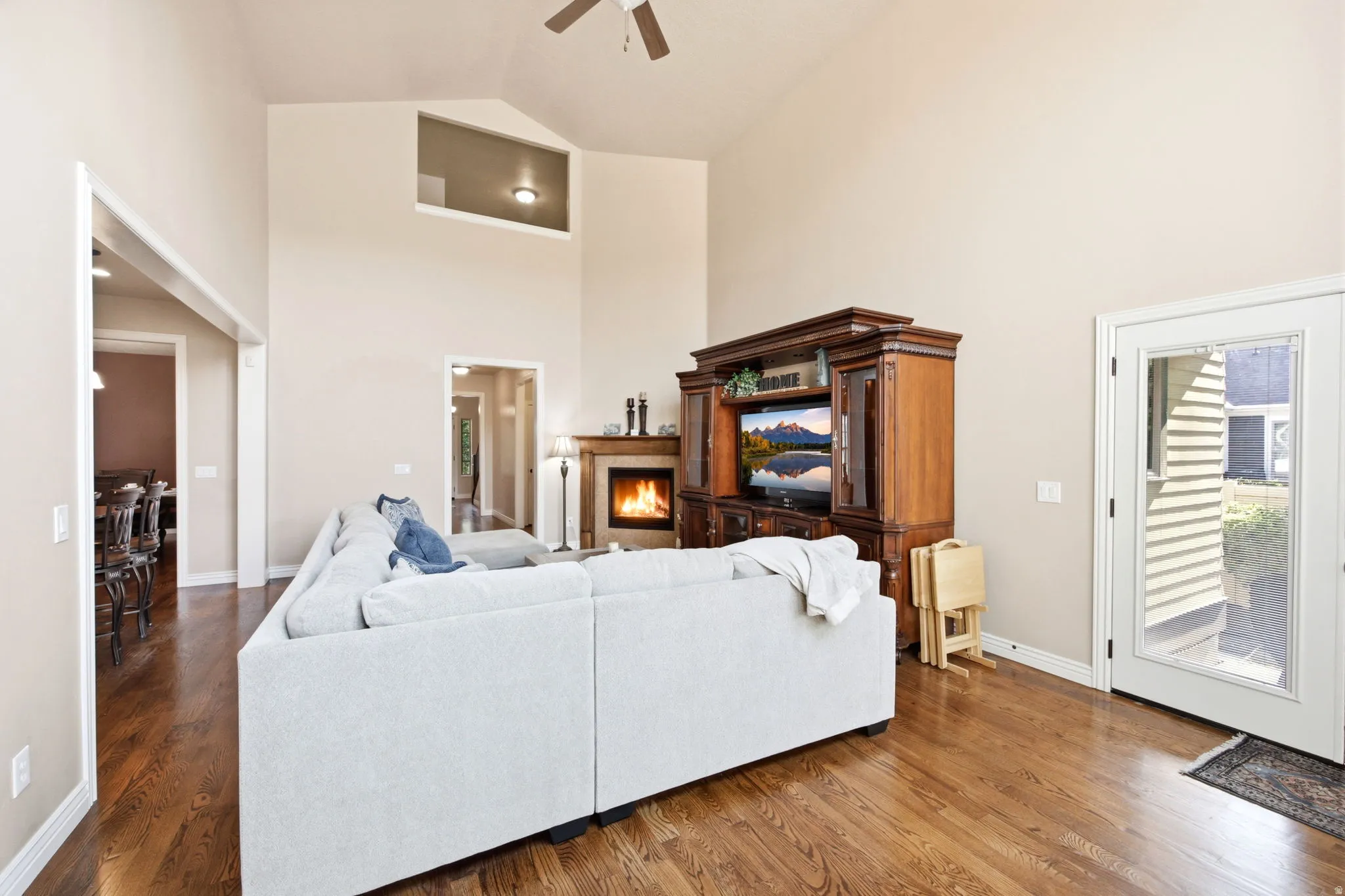 Living area featuring vaulted ceilings, wood-finish flooring, and a fireplace with a wood mantle