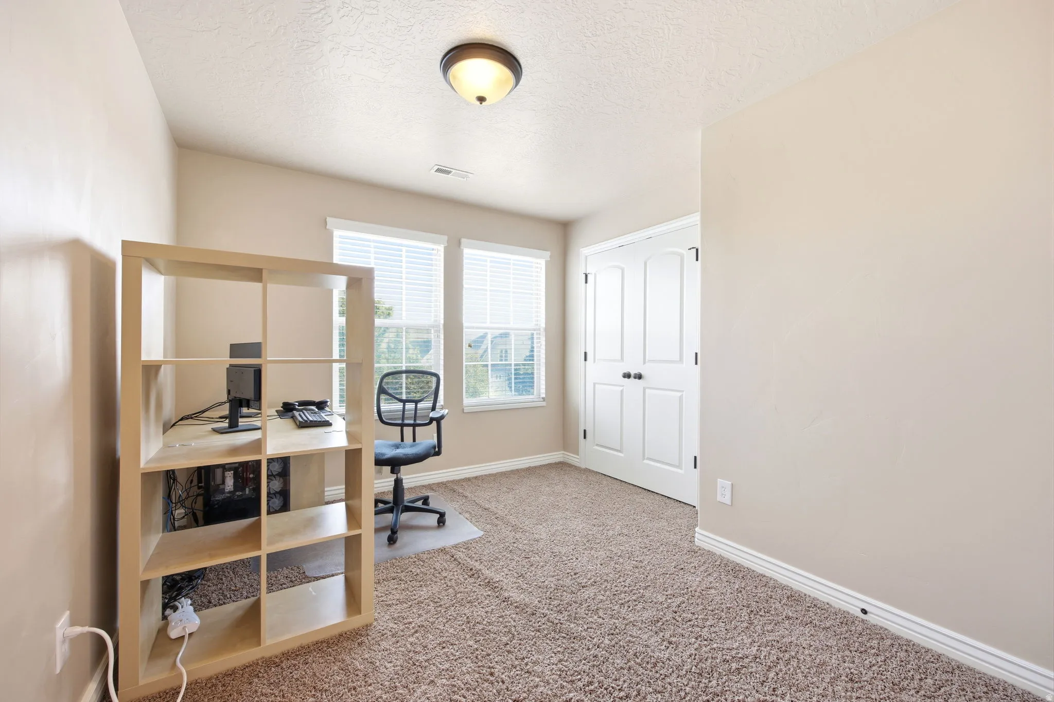 Room featuring beige carpeting, light neutral wall paint, and white baseboards