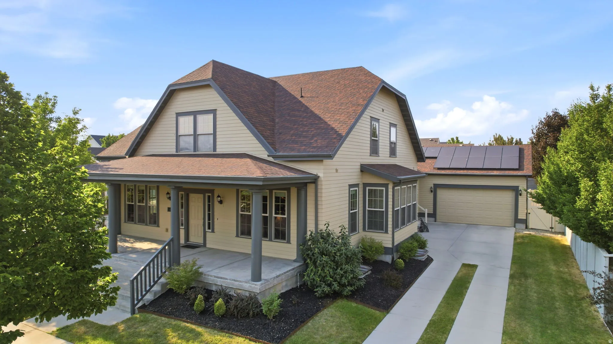 Craftsman-style residence featuring a covered front porch, an attached two-car garage, and a concrete driveway