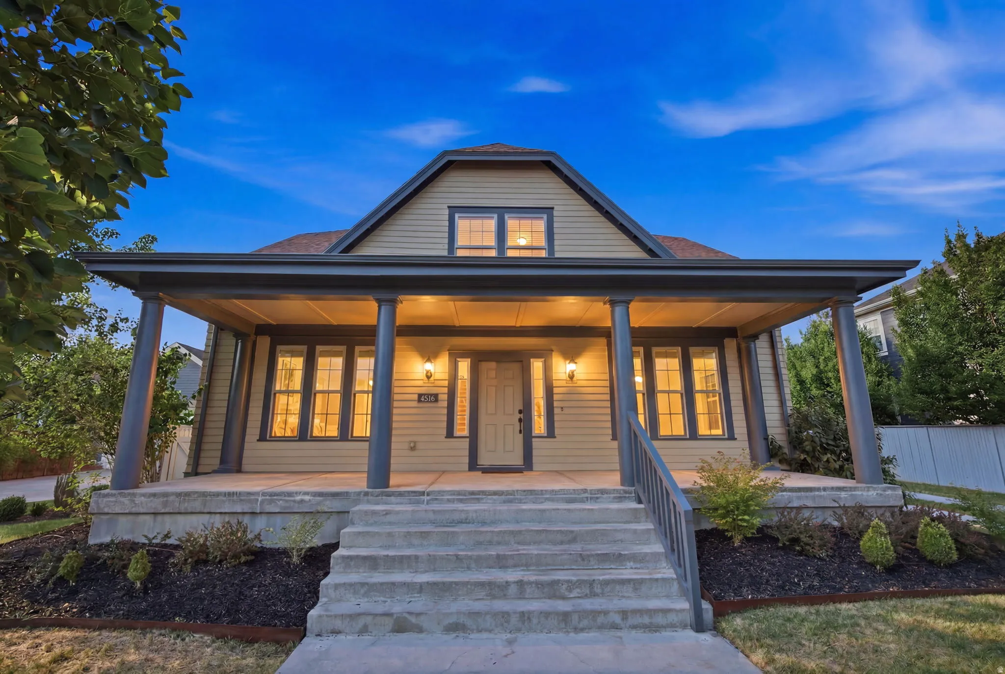 Inviting front porch with substantial columns, a gabled roofline, and dormer window