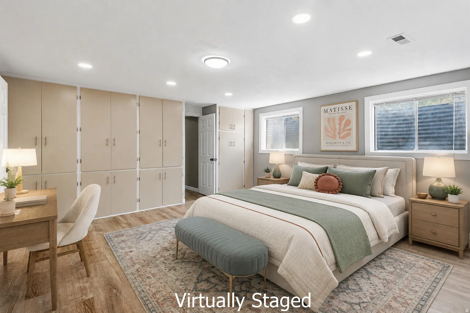 Spacious room featuring extensive built-in cabinetry, wood-finish flooring, recessed lighting, and two windows