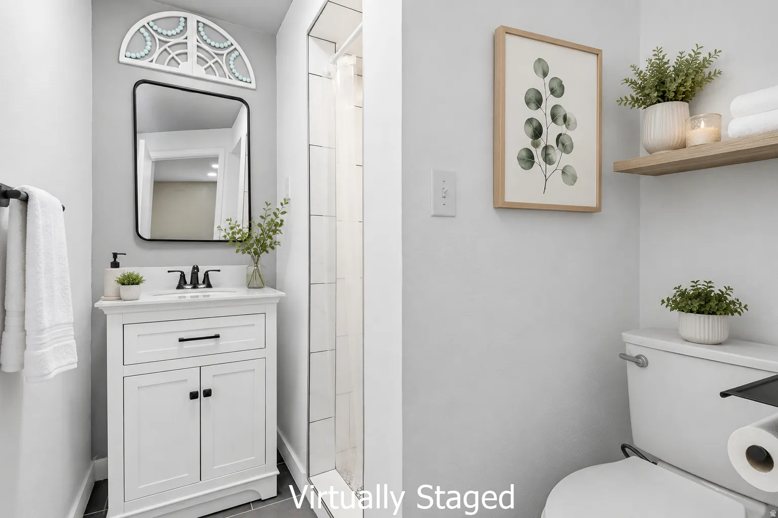 Bathroom featuring a white vanity with integrated sink, rectangular mirror, and dark hardware