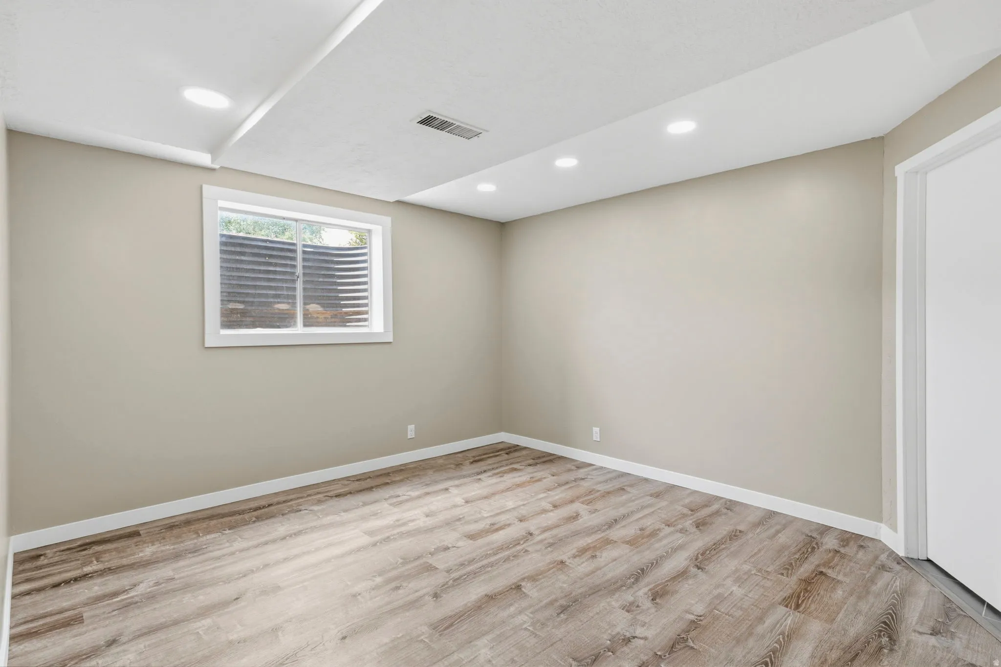 Neutral tone walls and wood-finish flooring define this room