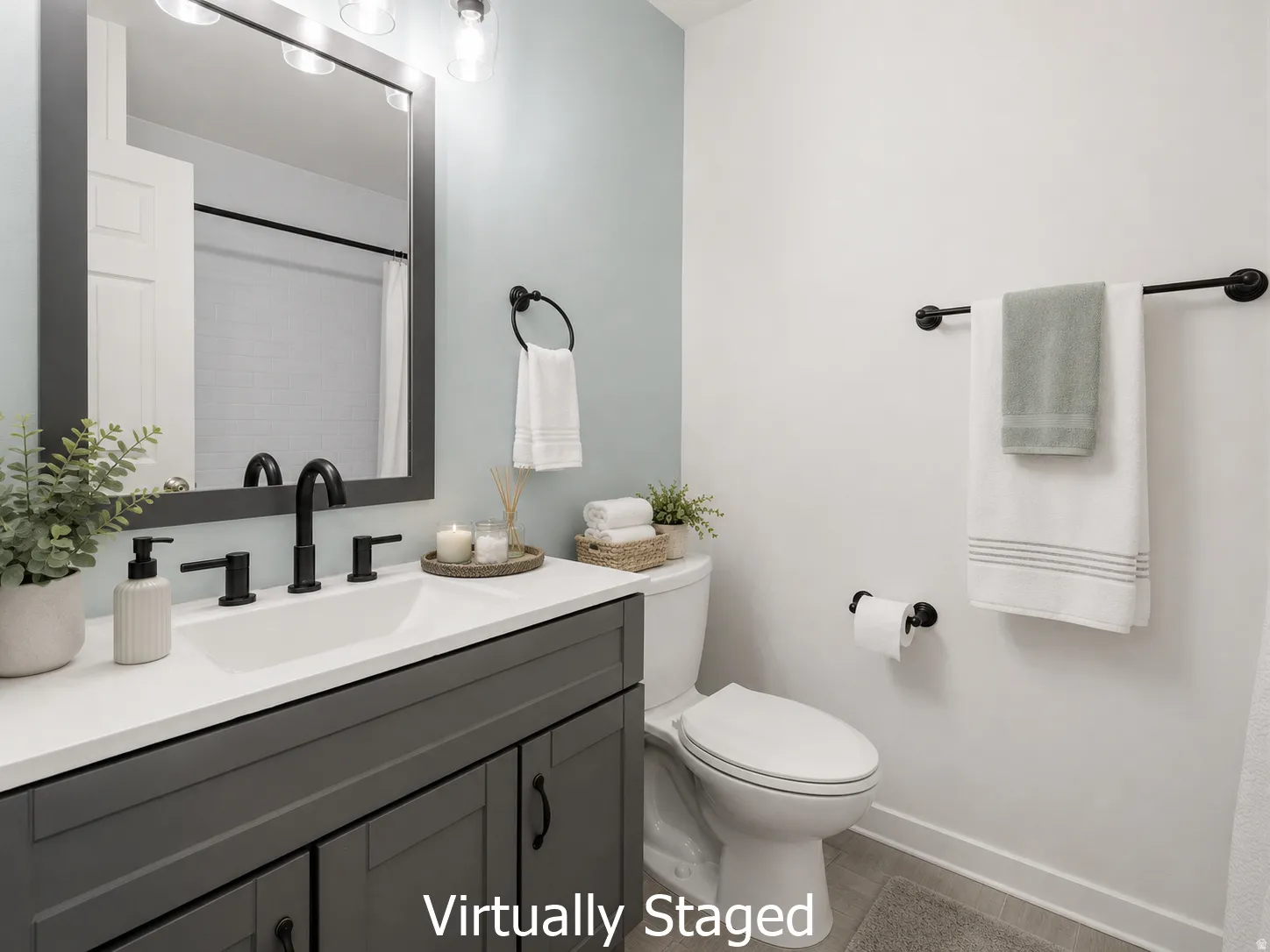 Bathroom featuring a dark gray vanity with a white countertop and integrated sink