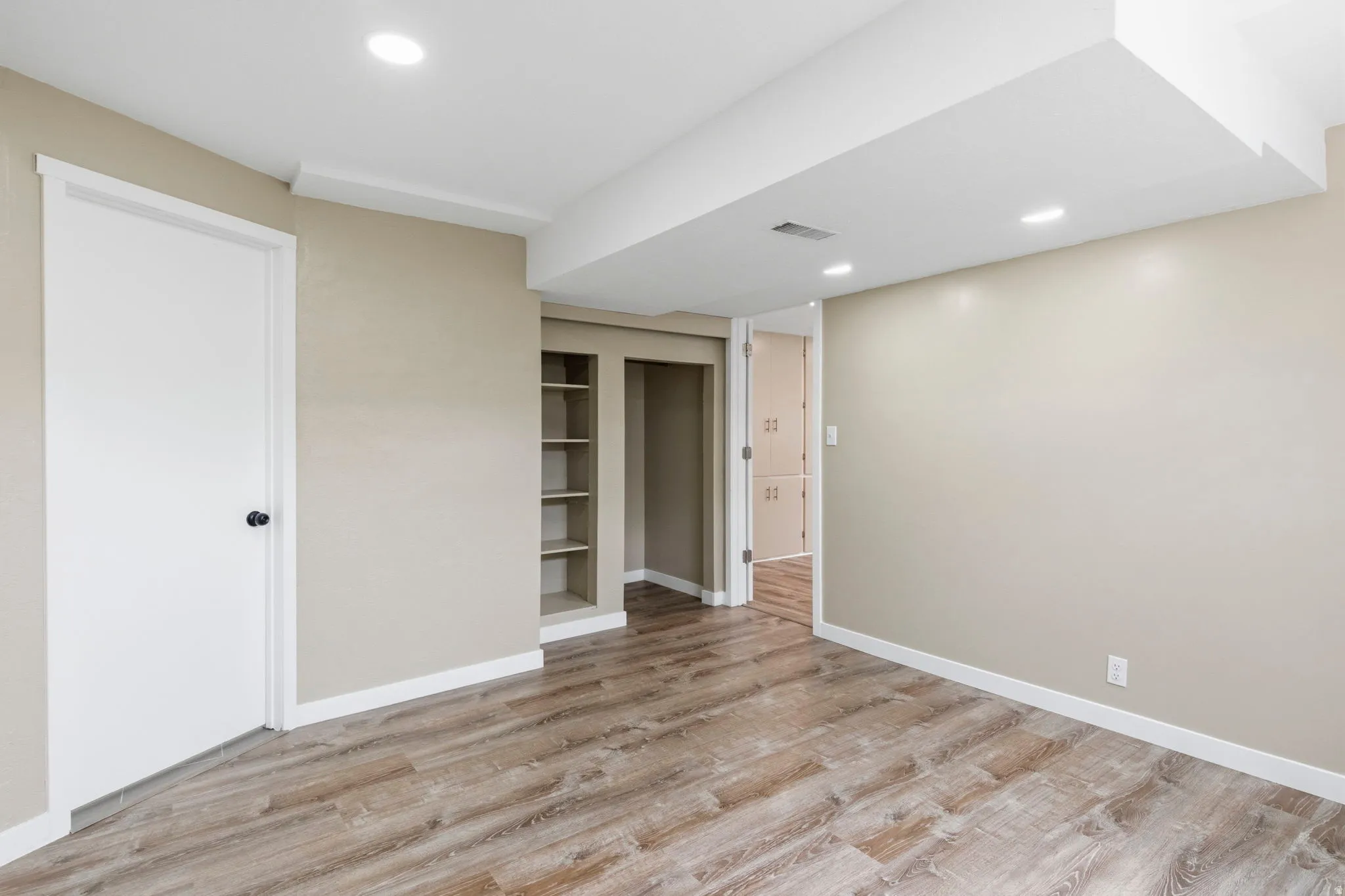 Spacious interior featuring wood-finish flooring, recessed lighting, and neutral wall tones