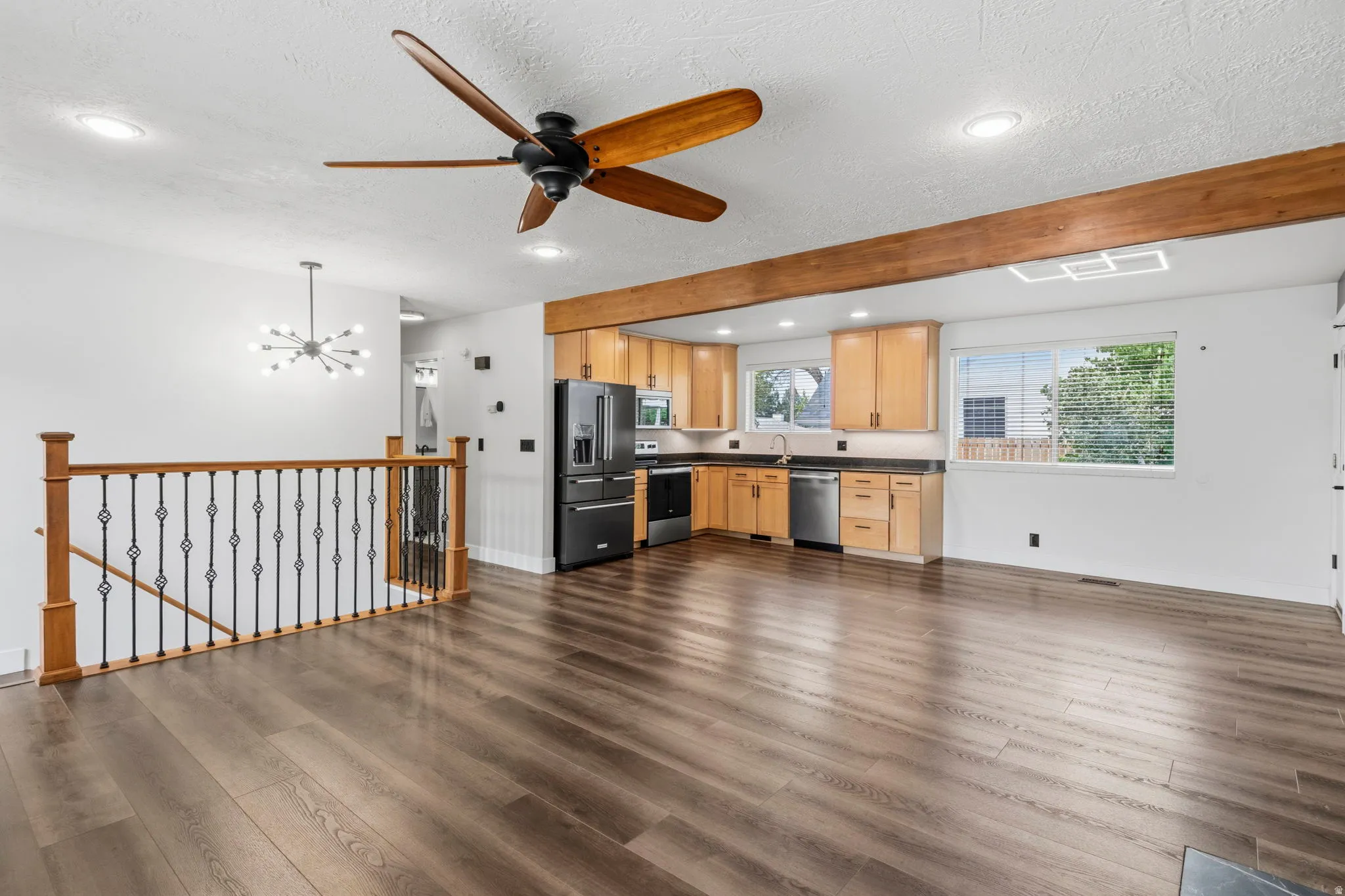 Open-concept living space featuring wood-finish flooring, a modern ceiling fan, and recessed lighting