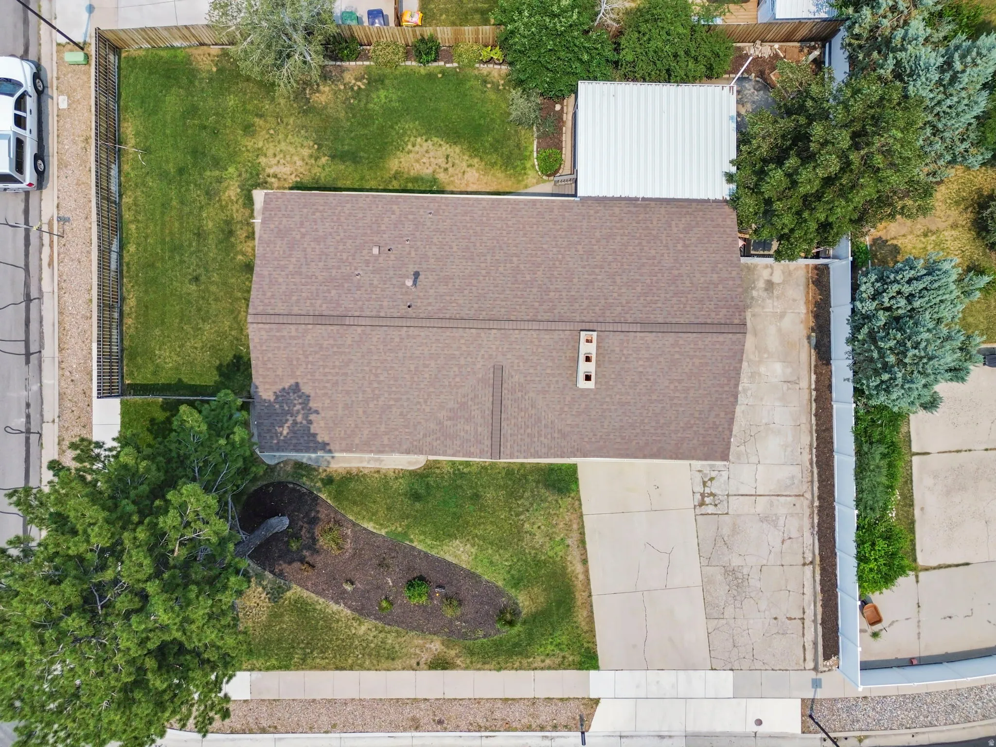 Property featuring a brown shingle roof, a concrete driveway, and a detached metal carport