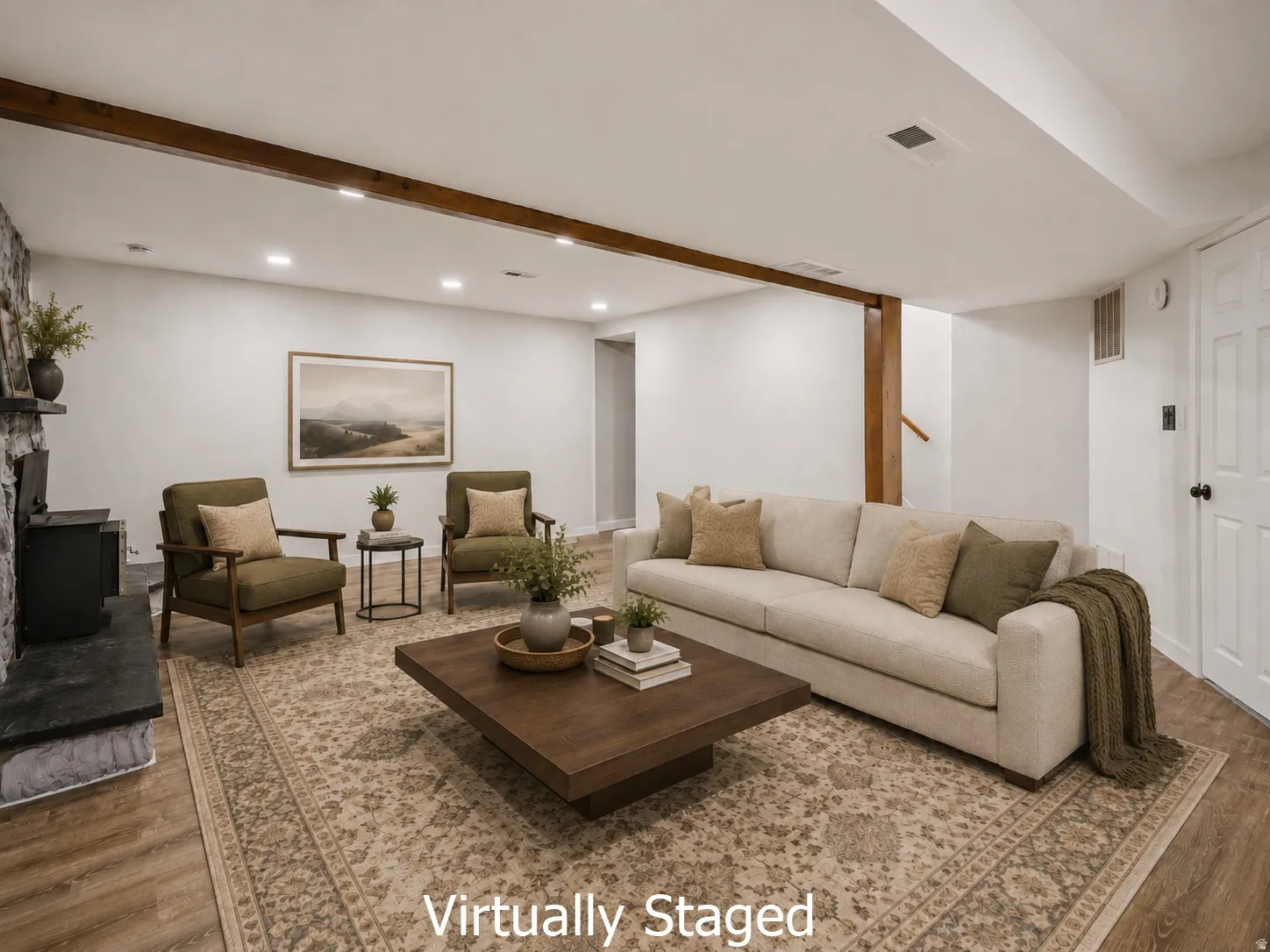 Spacious lower level featuring wood-finish flooring, a stone-faced fireplace with hearth, exposed wood ceiling beams, recessed lighting, and a paneled white door