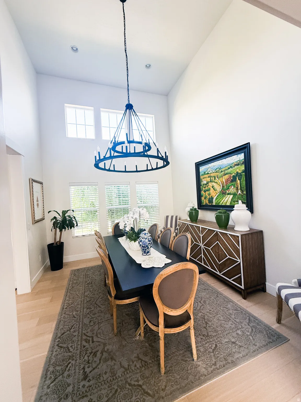 Dining area featuring a soaring ceiling, light wood-finish flooring, and west facing windows for beautiful natural light